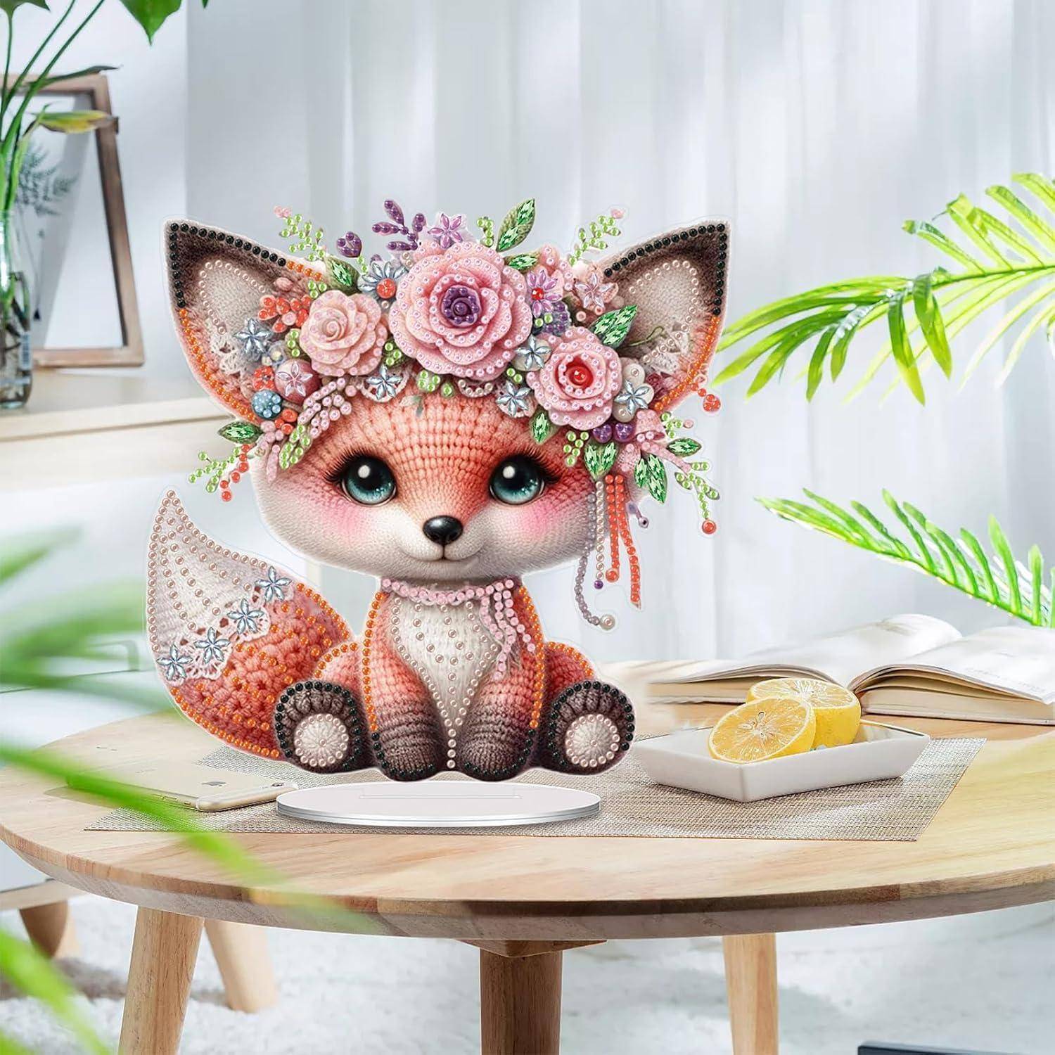 Niedliche Fuchsfigur mit Blumenkrone sitzt auf einem Tisch neben einem aufgeschlagenen Buch und Zitronenscheiben in einem hellen Raum.
