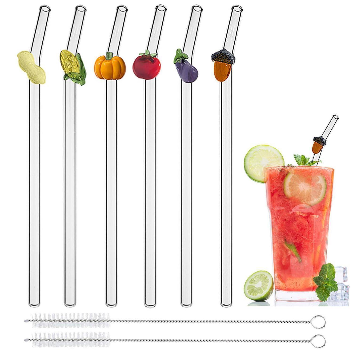 Satz aus langen Glastrinkhalmen mit Obst- und Gemüseverzierungen sowie ein roter Cocktail mit Zitrusfrüchten und Minze garniert.