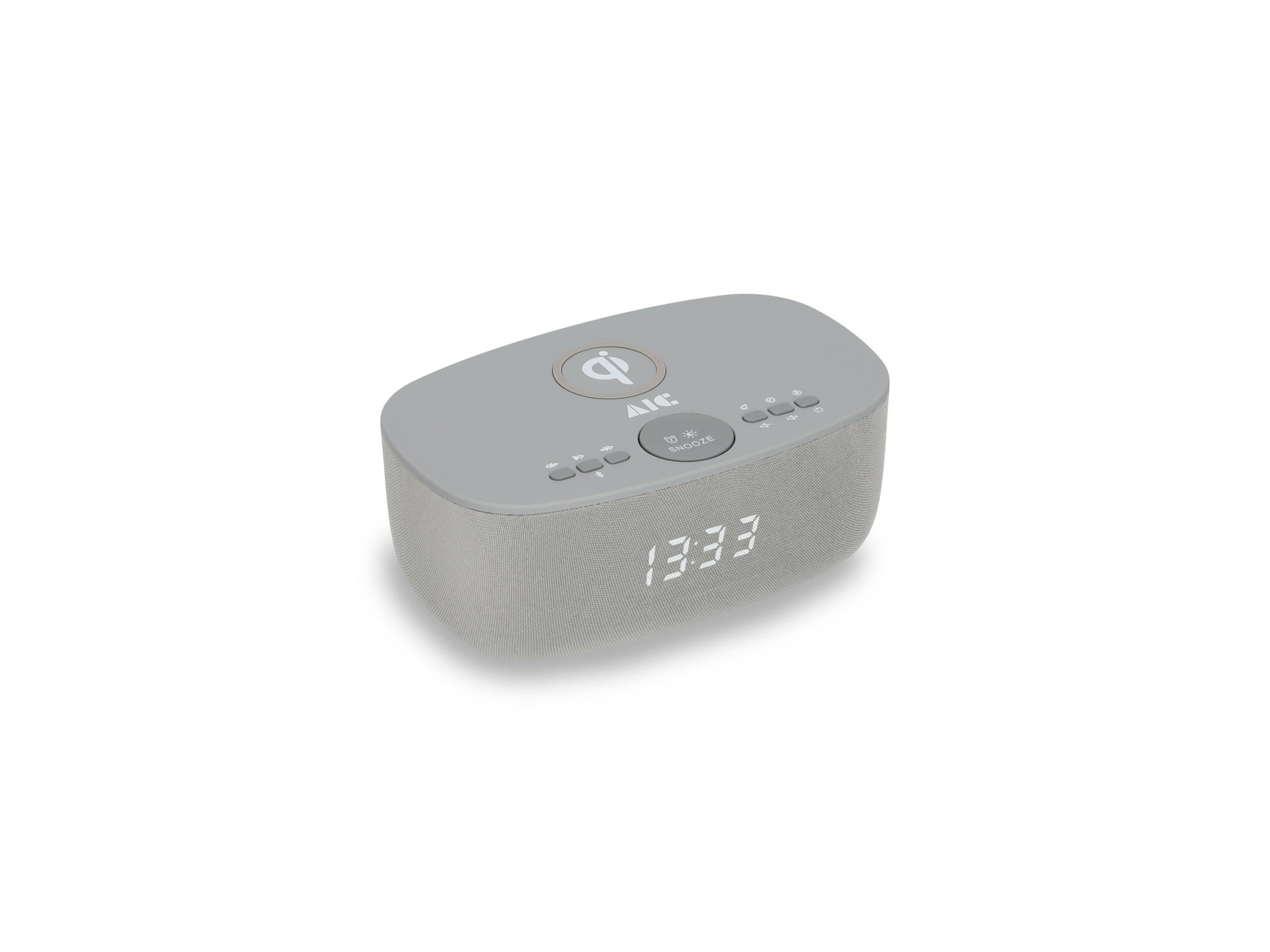 Grauer Nachttisch-Wecker mit Lautsprecher zeigt 13:33 an, mit Tasten und einem Wireless-Charging-Symbol oben.