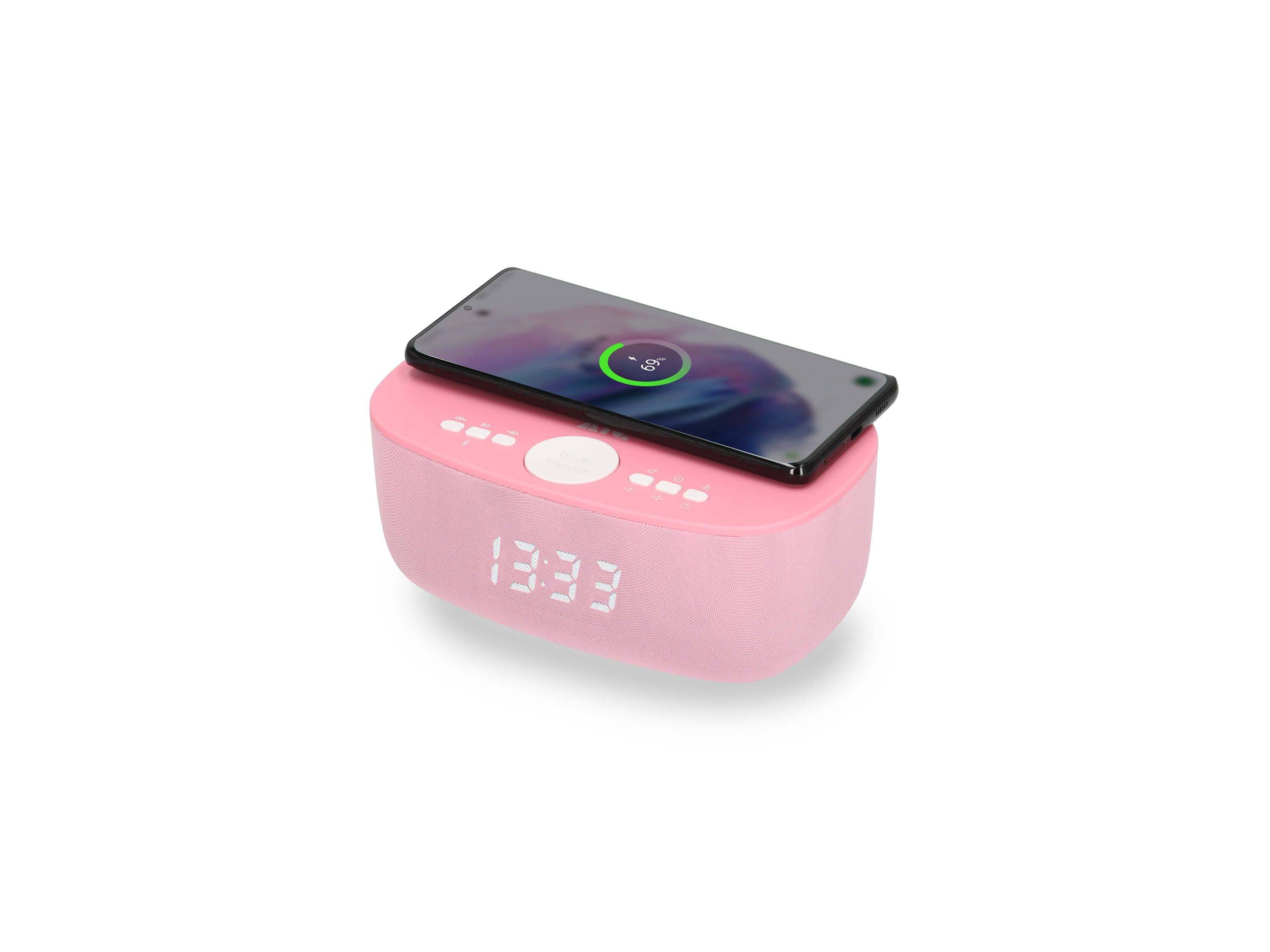 Rosa kabelloses Ladegerät Wecker Lautsprecher mit einem Smartphone oben drauf, das ein Ladesymbol und digitale Zeitanzeige zeigt.