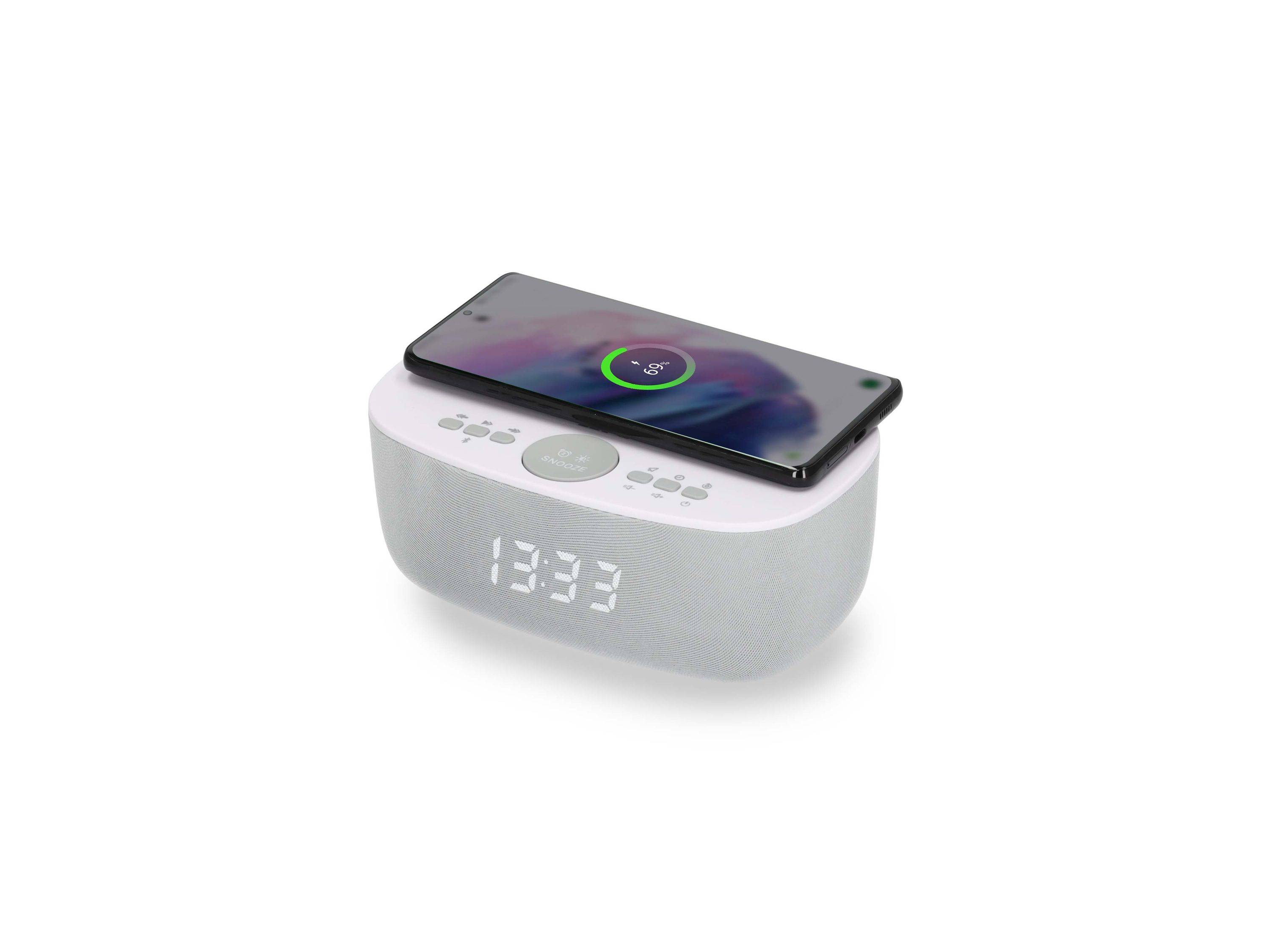 Ein Smartphone lädt drahtlos auf einem digitalen Wecker auf, dessen beleuchtetes Display 13:33 anzeigt.