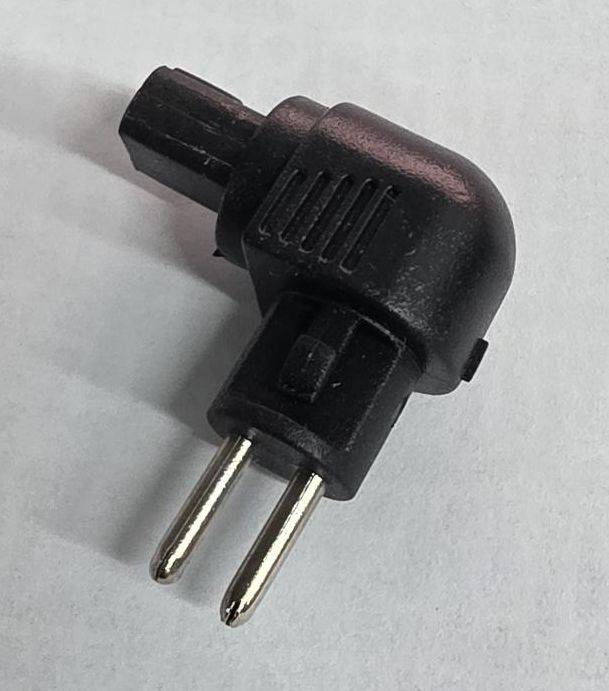 Schwarzer Stecker-Adapter mit rechtem Winkel und zwei Stiften auf hellem Hintergrund.