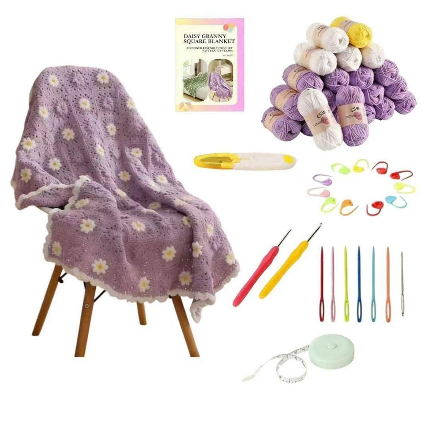 Gehäkelte lila Gänseblümchen-Omas-Quadrat-Decke auf Stuhl mit beigefügtem Musterheft, Wollknäueln, Häkelhaken, Maschenmarkierern und Messlatte.