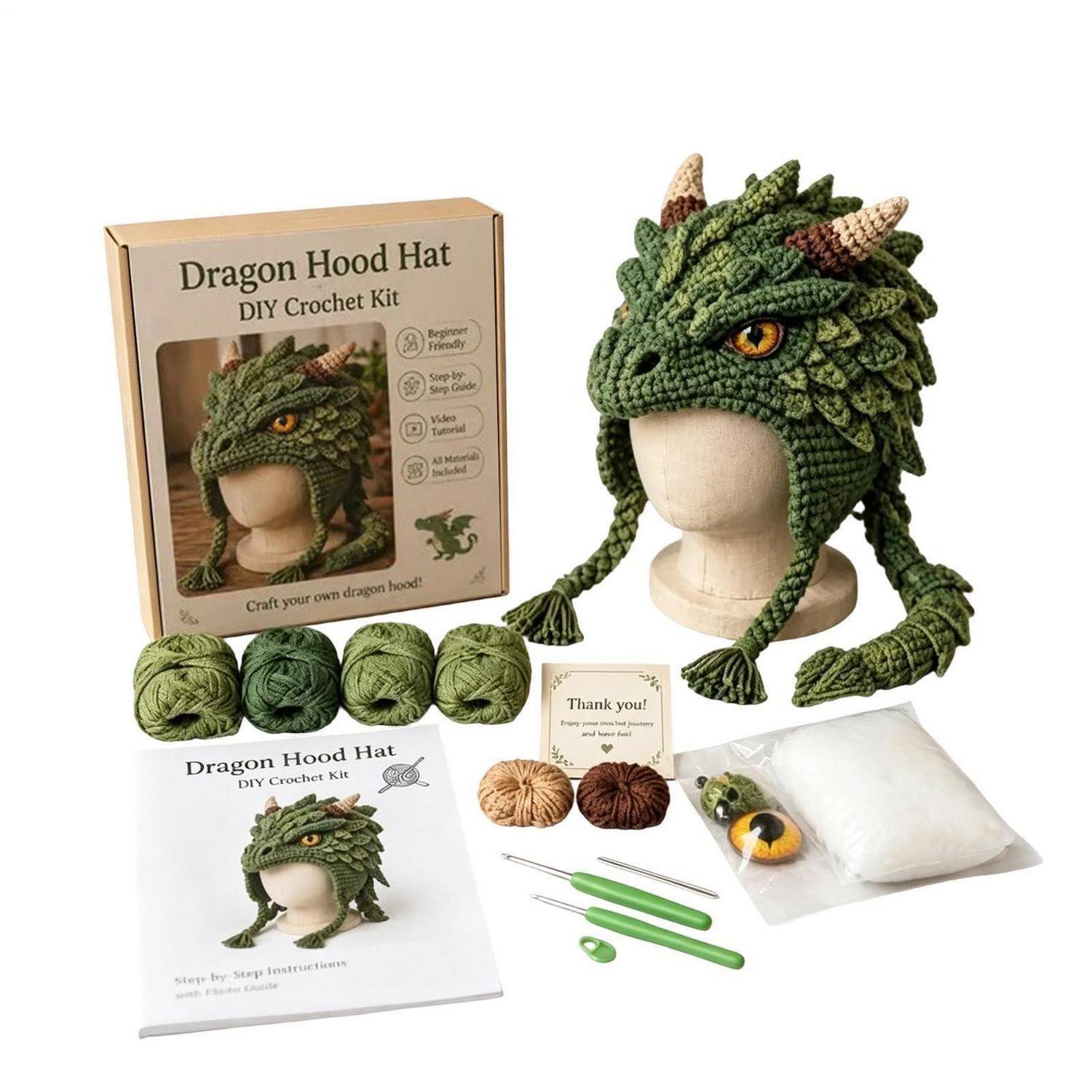 Häkelset für eine Drachenkapuzenmütze, zeigt die fertige grüne Drachenmütze auf einer Schneiderpuppe sowie enthaltenes Garn, Häkelhaken, Anleitung, Füllung und Zubehör.