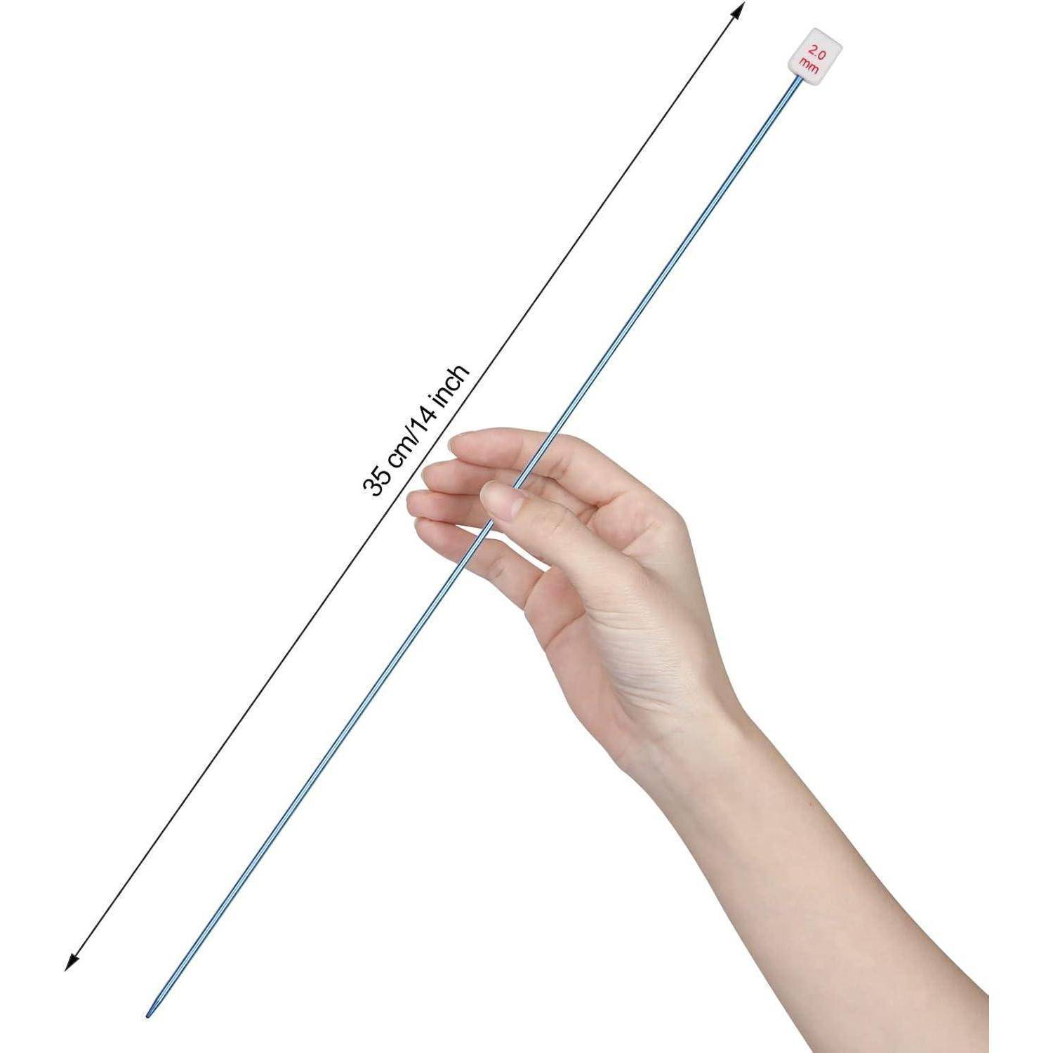 Hand, die eine 35 cm (14 Zoll) lange dünne Metallstricknadel mit einer nummerierten Kappe hält, vor weißem Hintergrund gezeigt.