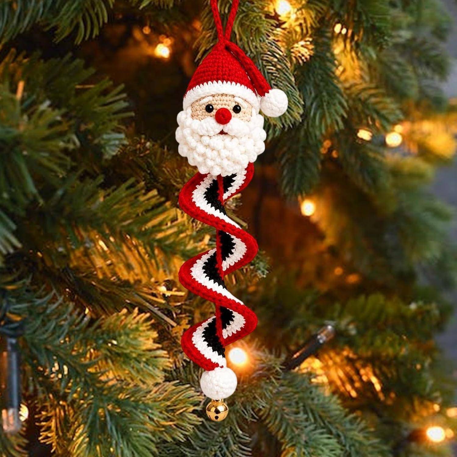 Gehäkelter Weihnachtsmannschmuck mit einem rot-weiß gestreiften spiralförmigen Körper, der an einem Weihnachtsbaum mit warmem Licht hängt.