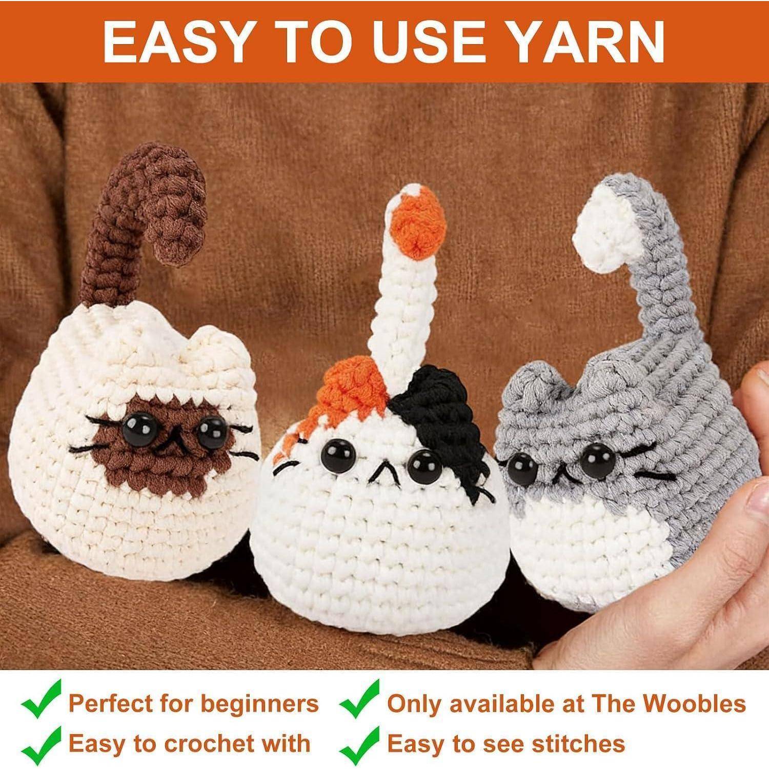 Werbung für benutzerfreundliches Garn mit drei gehäkelten Plüschtieren mit Katzengesichtern und dem Text „Perfekt für Anfänger", „Leicht zu häkeln"", „Nur bei The Woobles erhältlich"" und „Maschen leicht zu sehen"