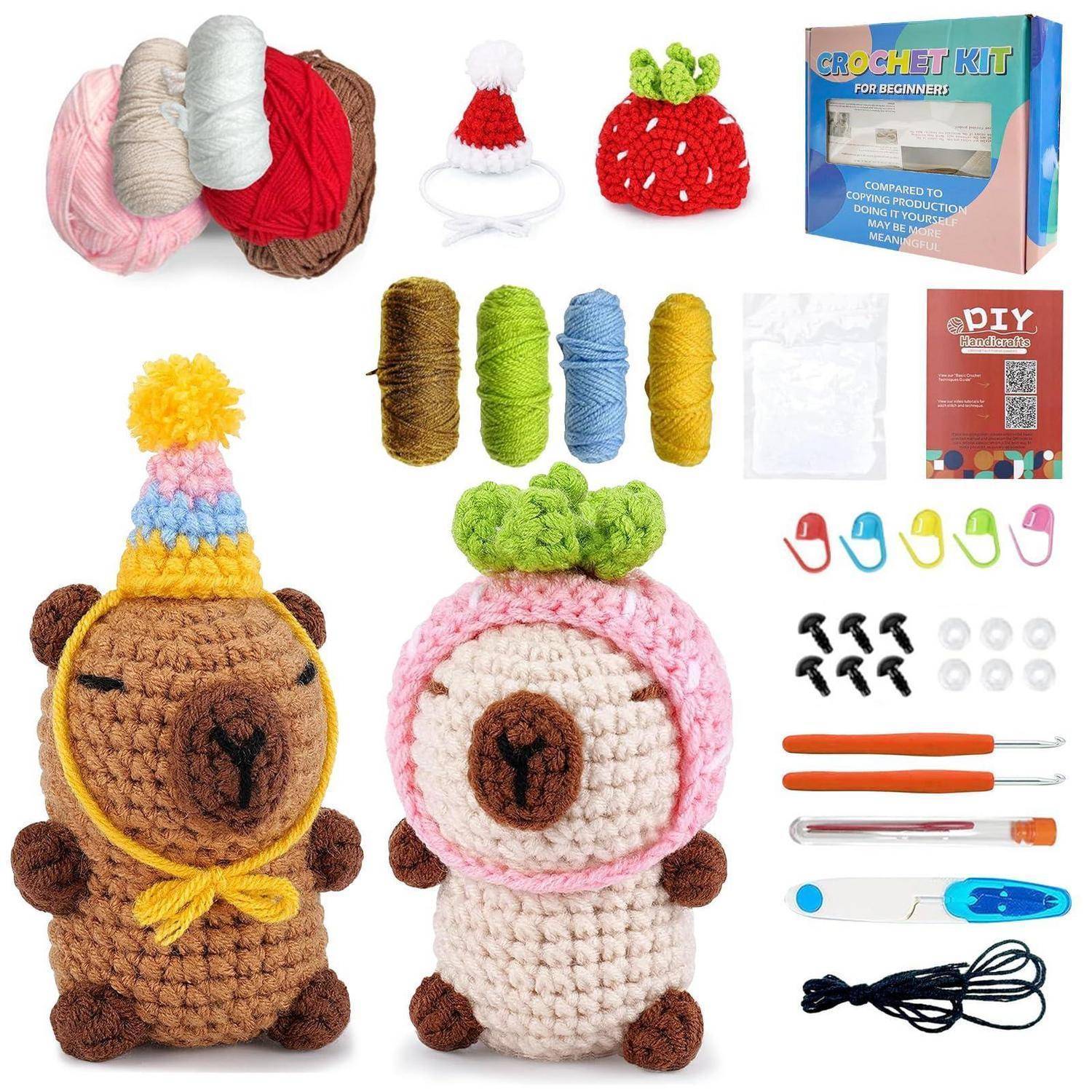 Inhalt des Häkelsets und fertige Plüschtiere: Garn, Häkelhaken, Markierungsnadeln, Füllmaterial, Anleitung und zwei gehäkelte Tierpuppen mit Hüten und Fruchtdetails.