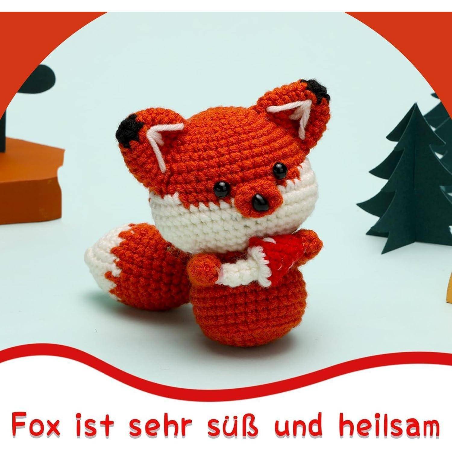 Gehäkelte rot-weiße Fuchsfigur mit deutschem Text „Fuchs ist sehr süß und heilsam" darunter.