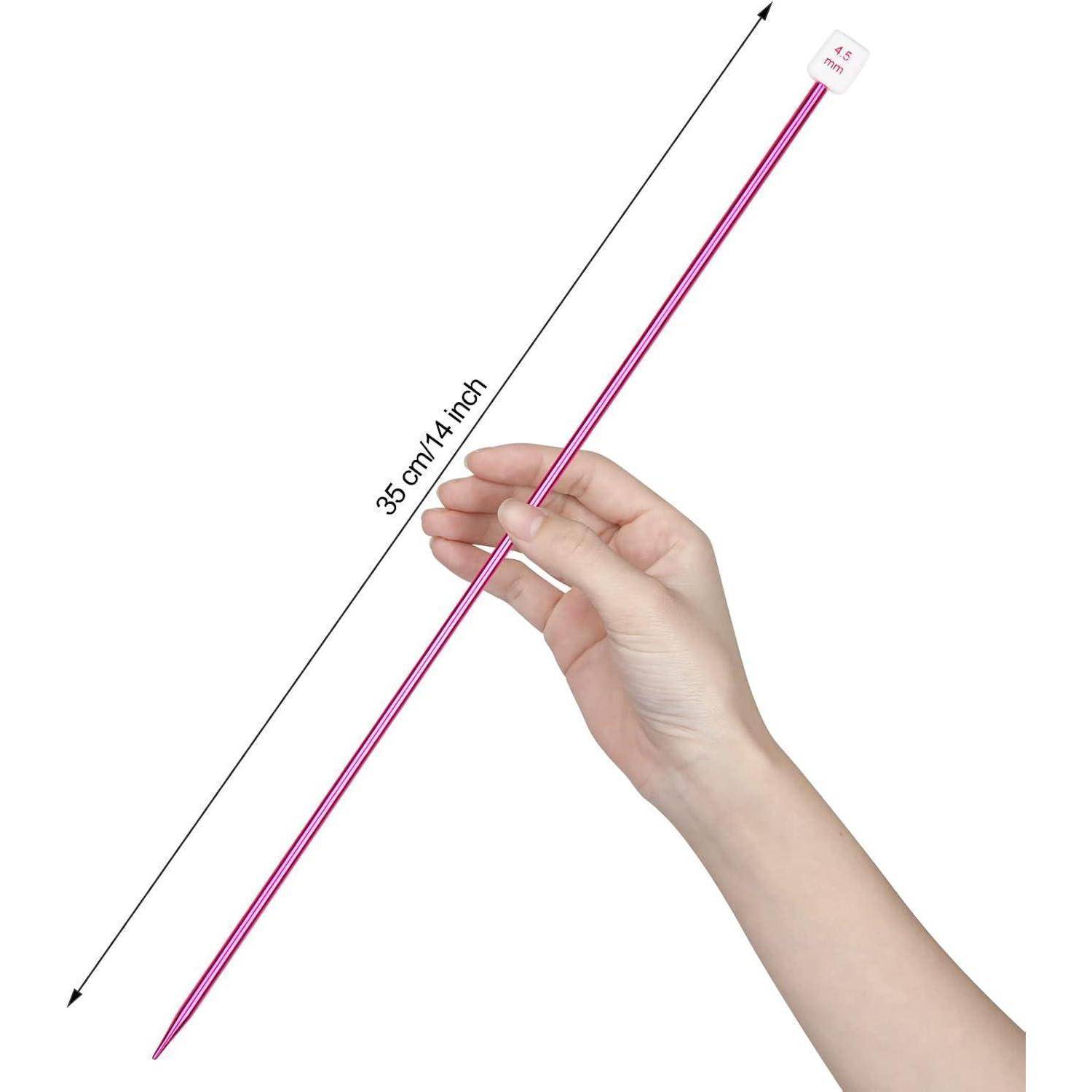 Hand, die eine rosa 35 cm (14 Zoll) Stricknadel gegen einen weißen Hintergrund hält.