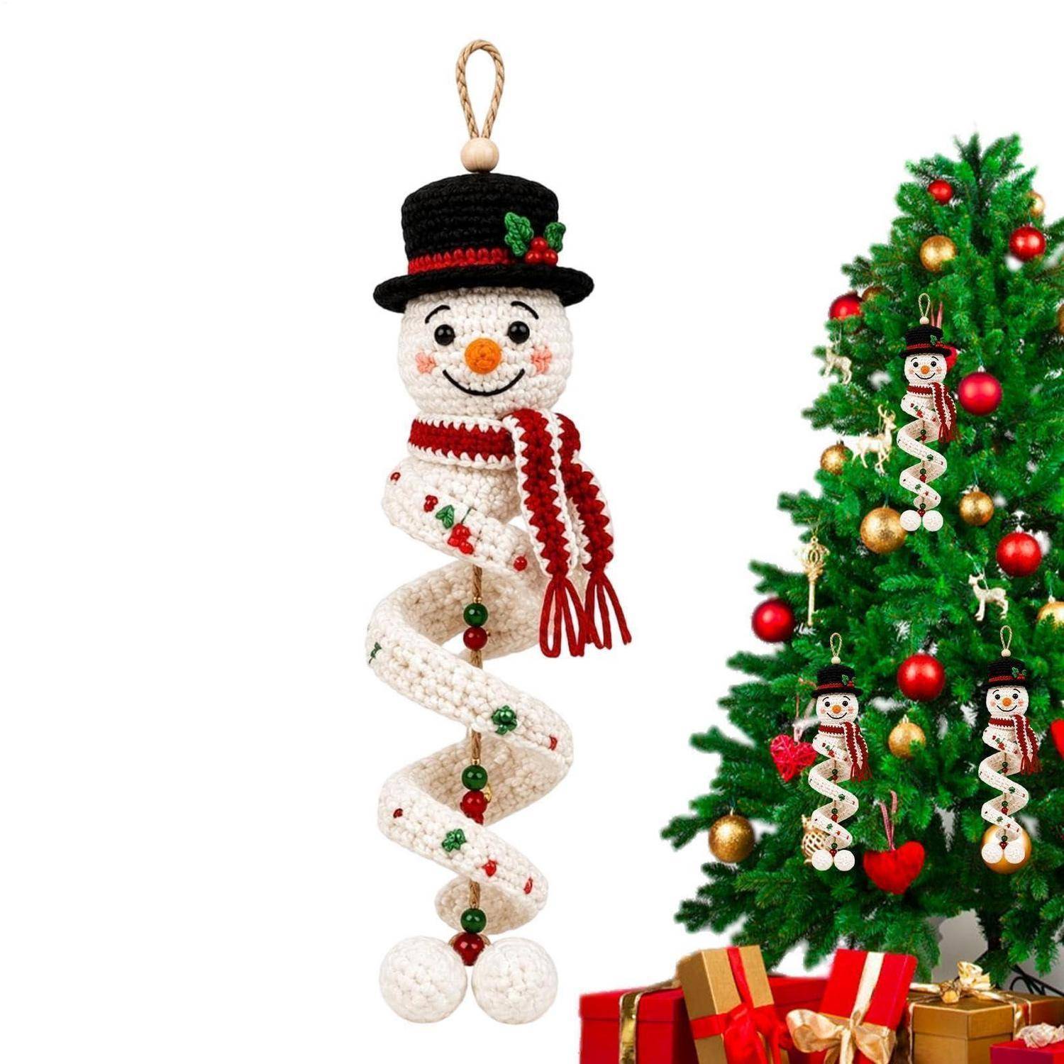 Gehäkelter Schneemann-Spiral-Ornament mit Schal und Mütze, gezeigt neben einem dekorierten Weihnachtsbaum mit passenden Ornamenten und Geschenken.