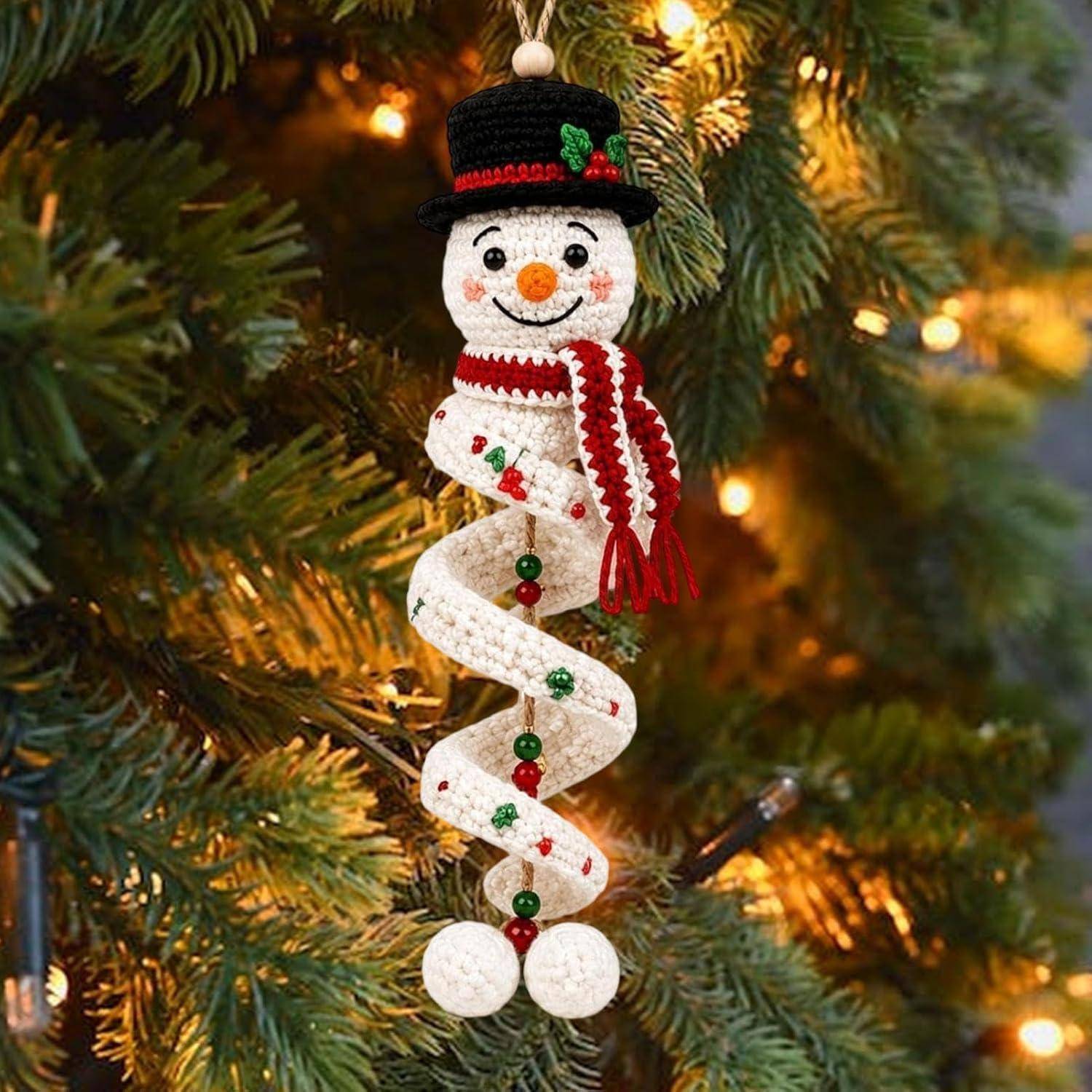 Handgefertigte Schneemann-Weihnachtsdekoration mit Hut und Schal, die an einem beleuchteten Immergrünbaum hängt