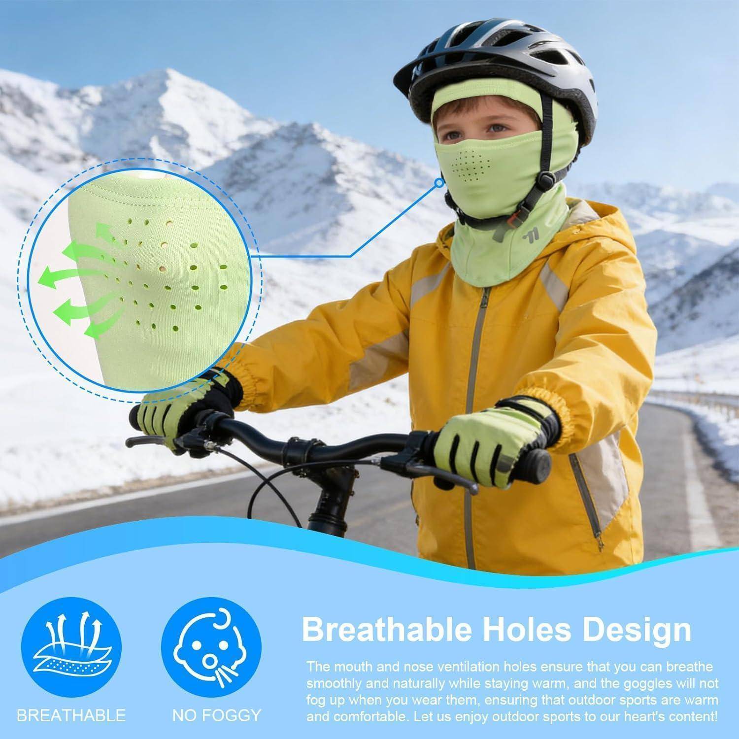 Kind in gelber Skijacke, Helm und Gesichtsmaske steht mit einem Fahrrad auf einer verschneiten Bergstraße; die Vergrößerung zeigt die atmungsaktiven Belüftungslöcher hervor.