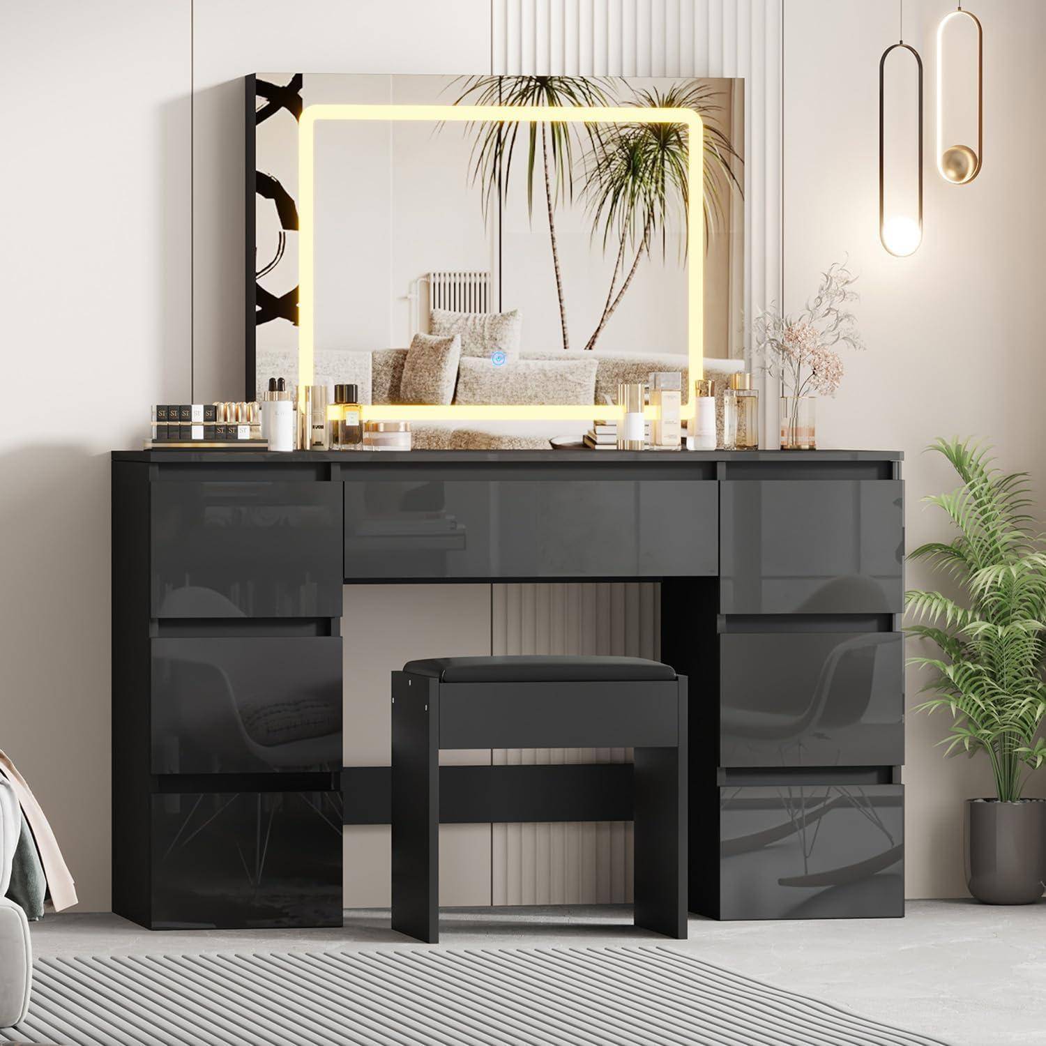 Modernes schwarzes Badezimmermöbel mit beleuchtetem Spiegel, Hocker, Kerzen und Topfpflanzen in einem hellen minimalistischen Raum.