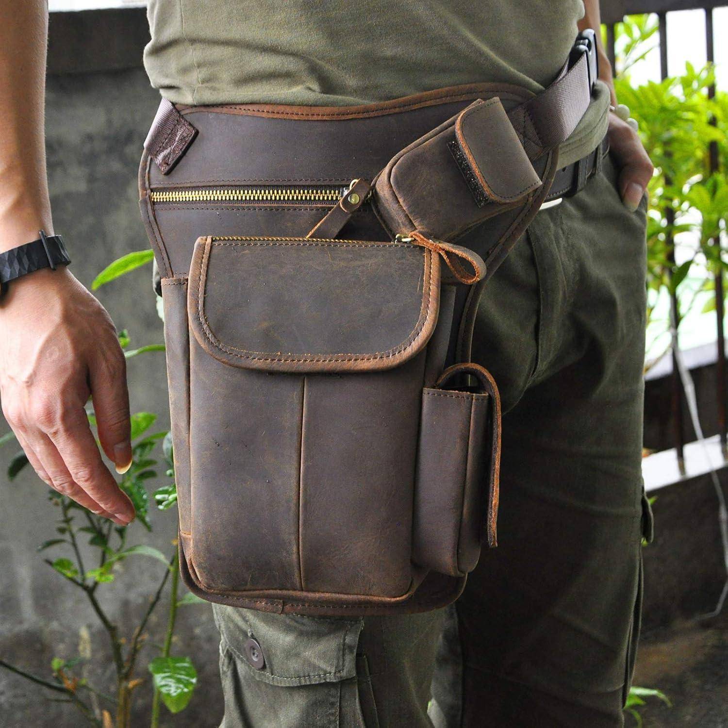 Person trägt eine braune Lederhüfttasche mit mehreren Taschen und einem Reißverschluss, die über olivfarbener Kleidung angebracht ist.