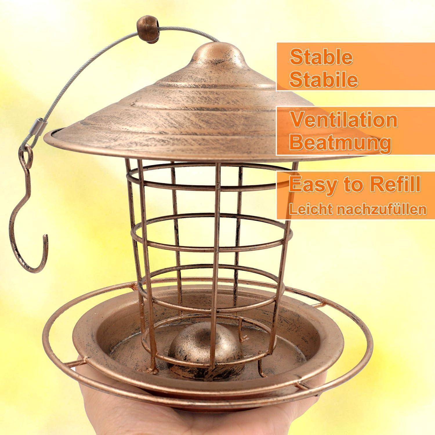 Nahaufnahme eines hängenden Vogelfutterhauses mit einem Metallkäfig und Sitzstangen, gekennzeichnet mit "Stabil"", ""Belüftung"" und ""Leicht nachzufüllen"".