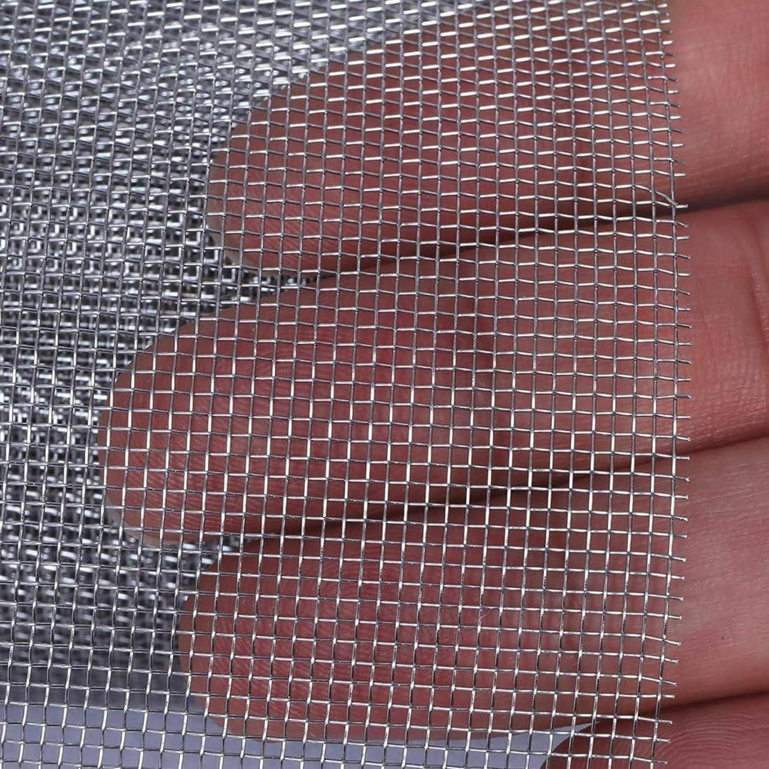 Nahaufnahme eines feinen Silbermetallgitters, das zwischen den Fingern gehalten wird, mit erkennbarem kleinem quadratischen Geflecht und Oberflächenstruktur.