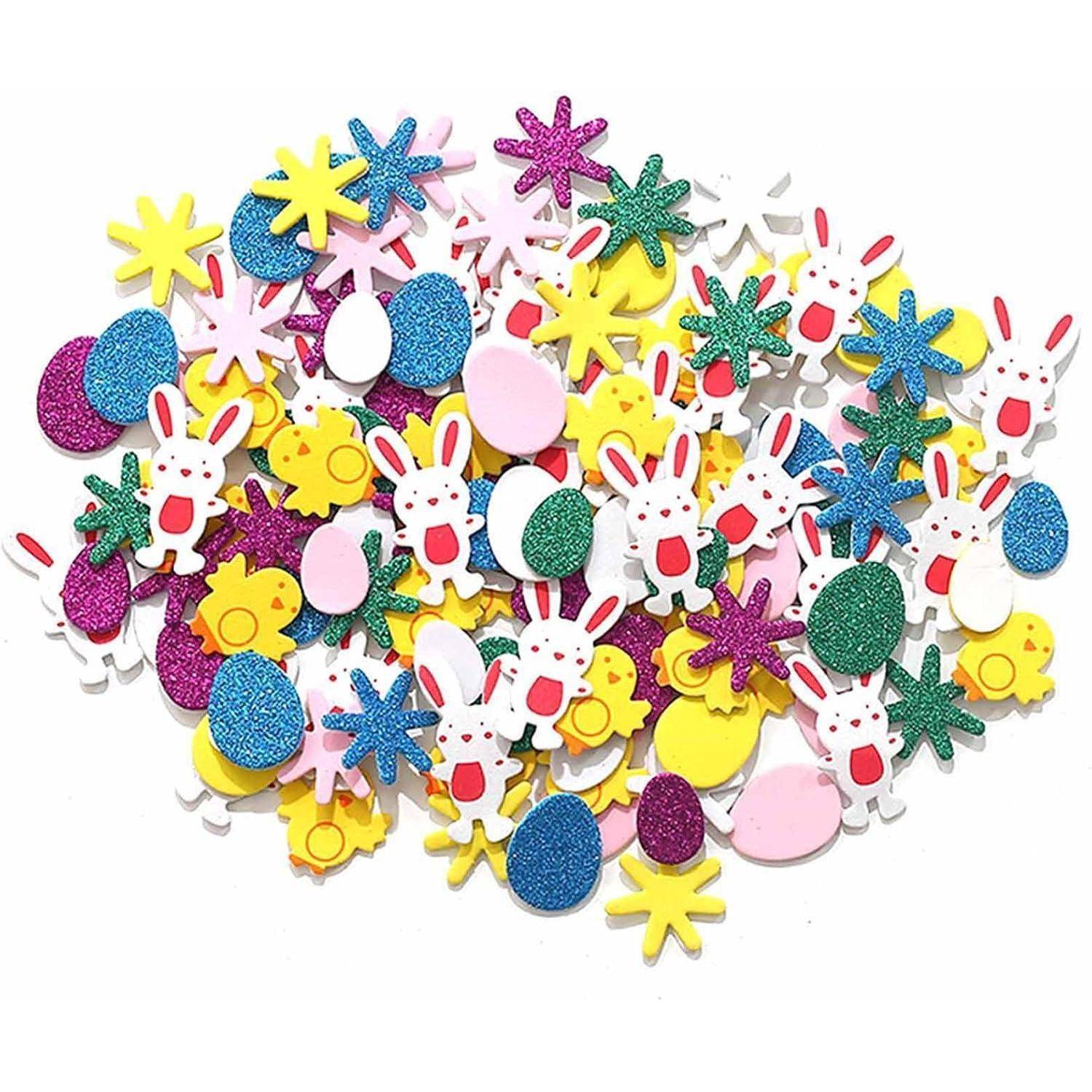 Sortiertes glitzerndes Osterhandwerk-Konfetti mit Hase, Ei, Blume und Sternformen verstreut auf weißem Hintergrund.