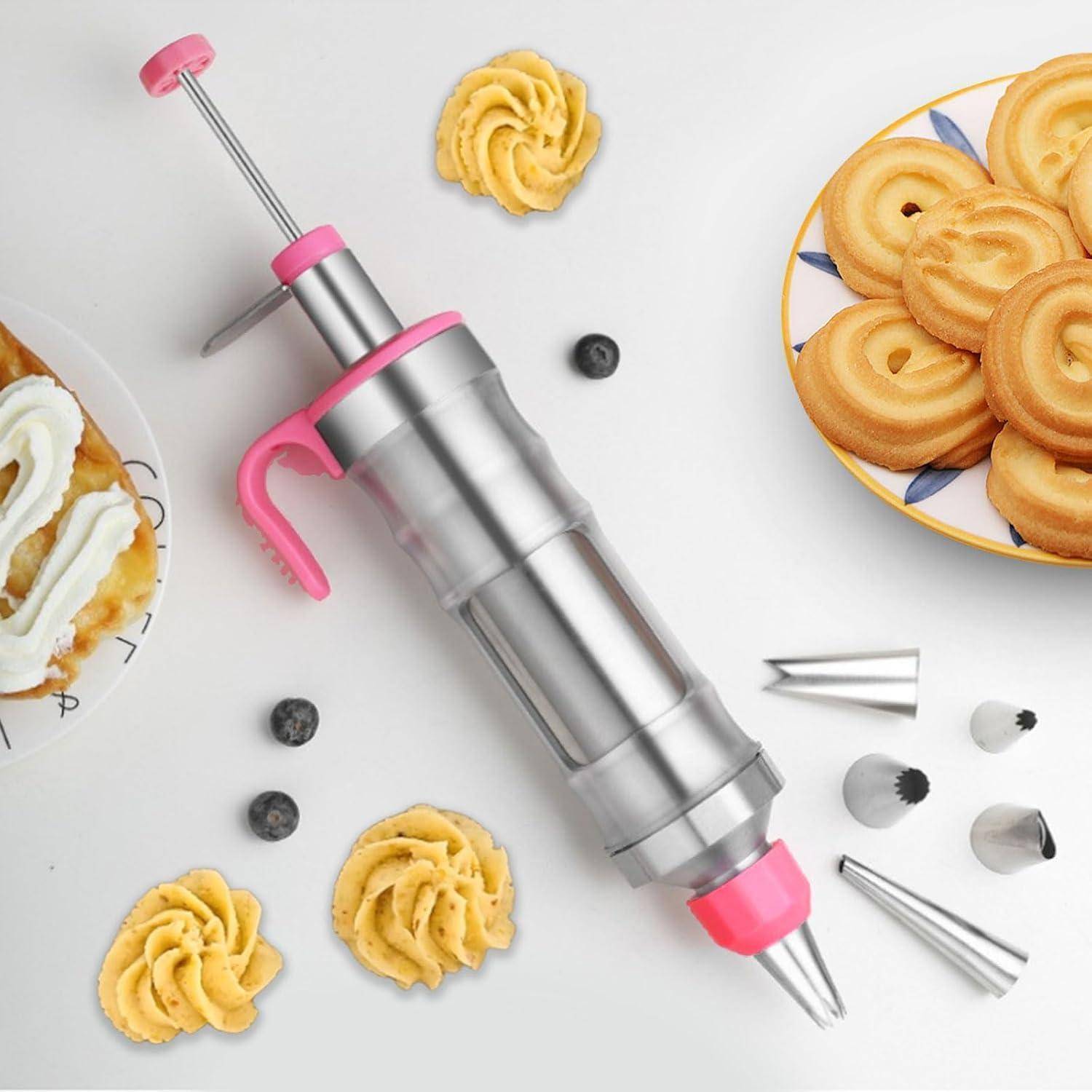 Gebäckdekorierspritzen mit rosa Akzenten und Metallspritztüllen, umgeben von gespritzte Glasur und Kekse auf weißem Hintergrund.