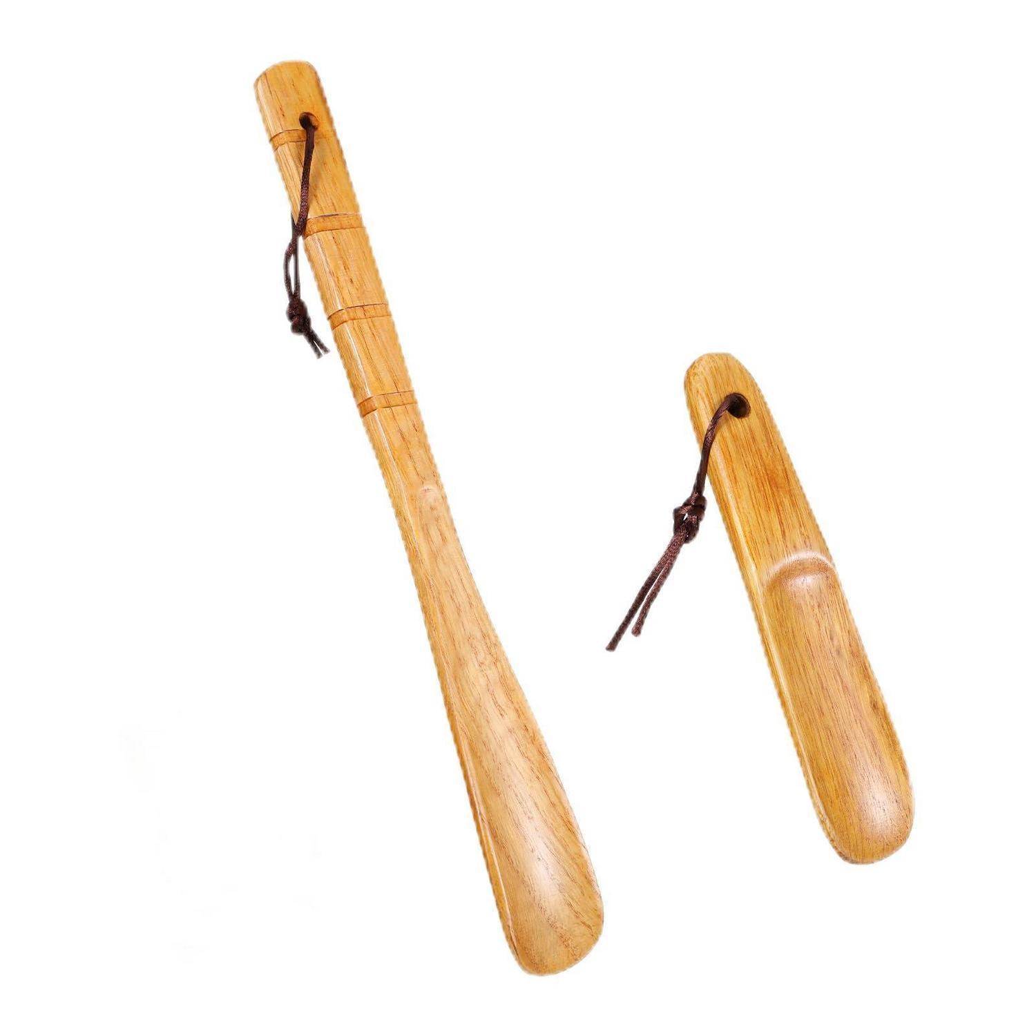 Zwei Schuhlöffel aus Holz mit Lederschnüren auf weißem Hintergrund.