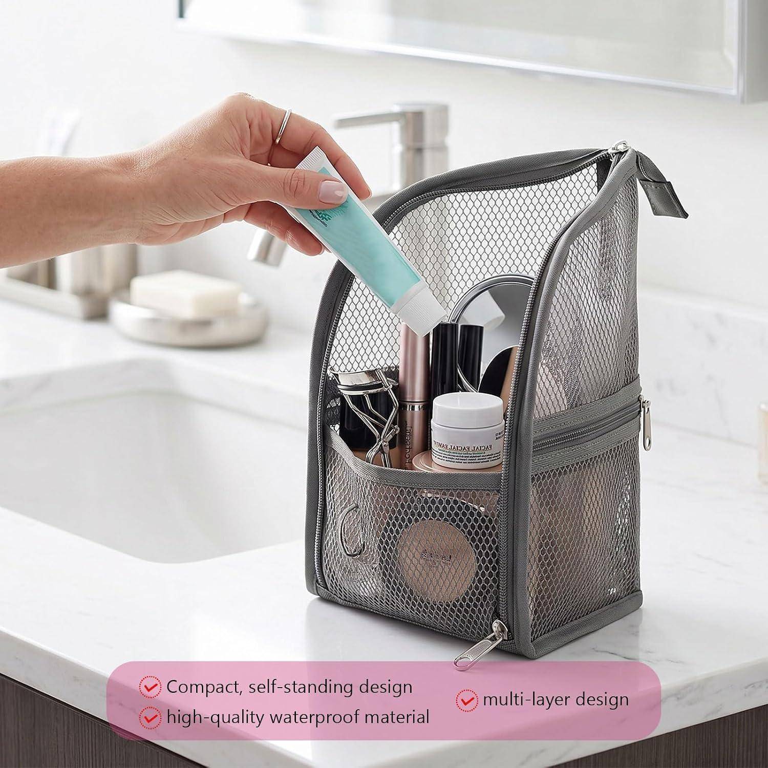 Hand legt ein Rohr in einen Mesh-Toilettenorganizer auf einer Badezimmerablage; Text hebt das kompakte, freistehende, mehrschichtige, wasserdichte Design hervor.
