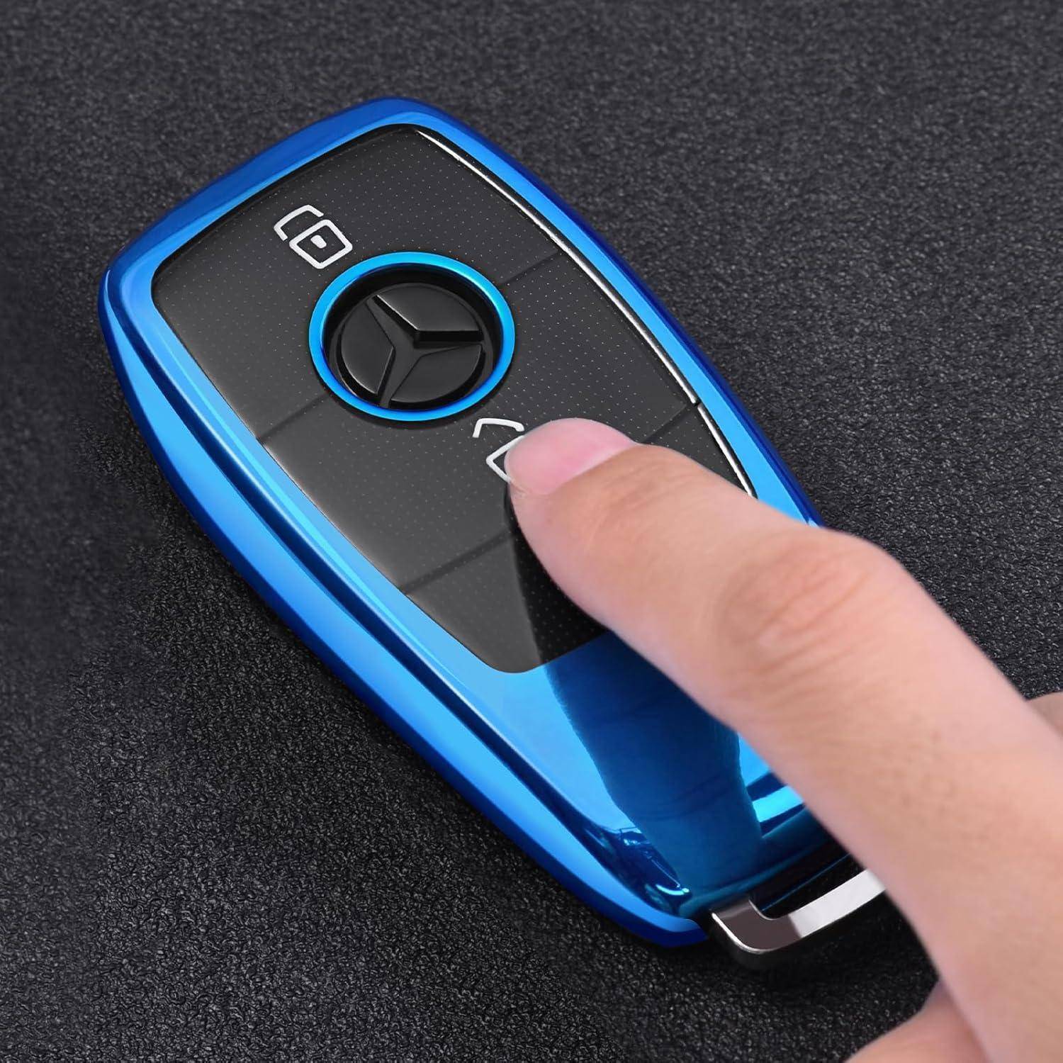 Nahaufnahme einer Hand, die die Entsperrtaste auf einer blauen Autoschlüsselfernbedienung drückt.