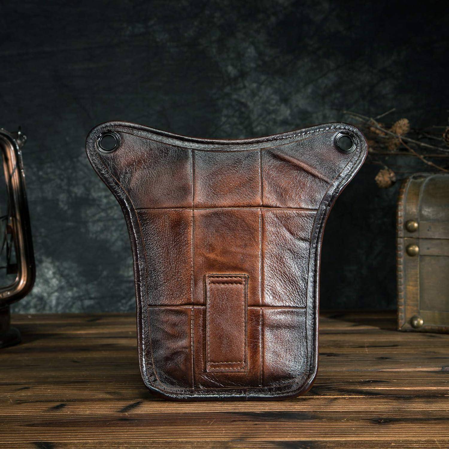 Braune Ledertasche mit Druckknopfecken und einer vorderen Tasche, aufrecht auf einem Holztisch stehend.