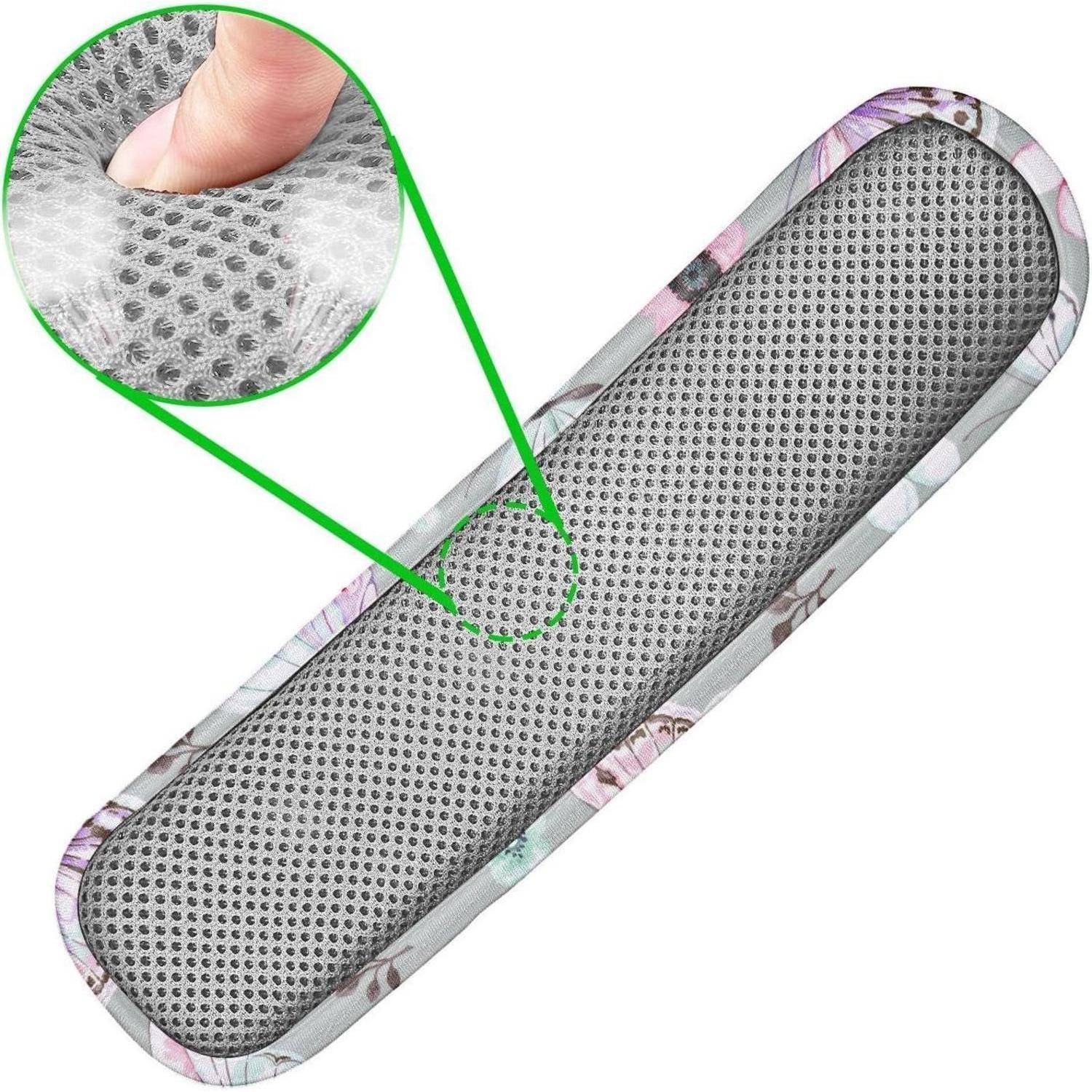 Eine Schuheinlage mit Blumenmuster und perforierter grauer Oberfläche, gezeigt mit einer vergrößerten Detailansicht ihrer gepolsterten Textur und einem Finger, der darauf drückt.