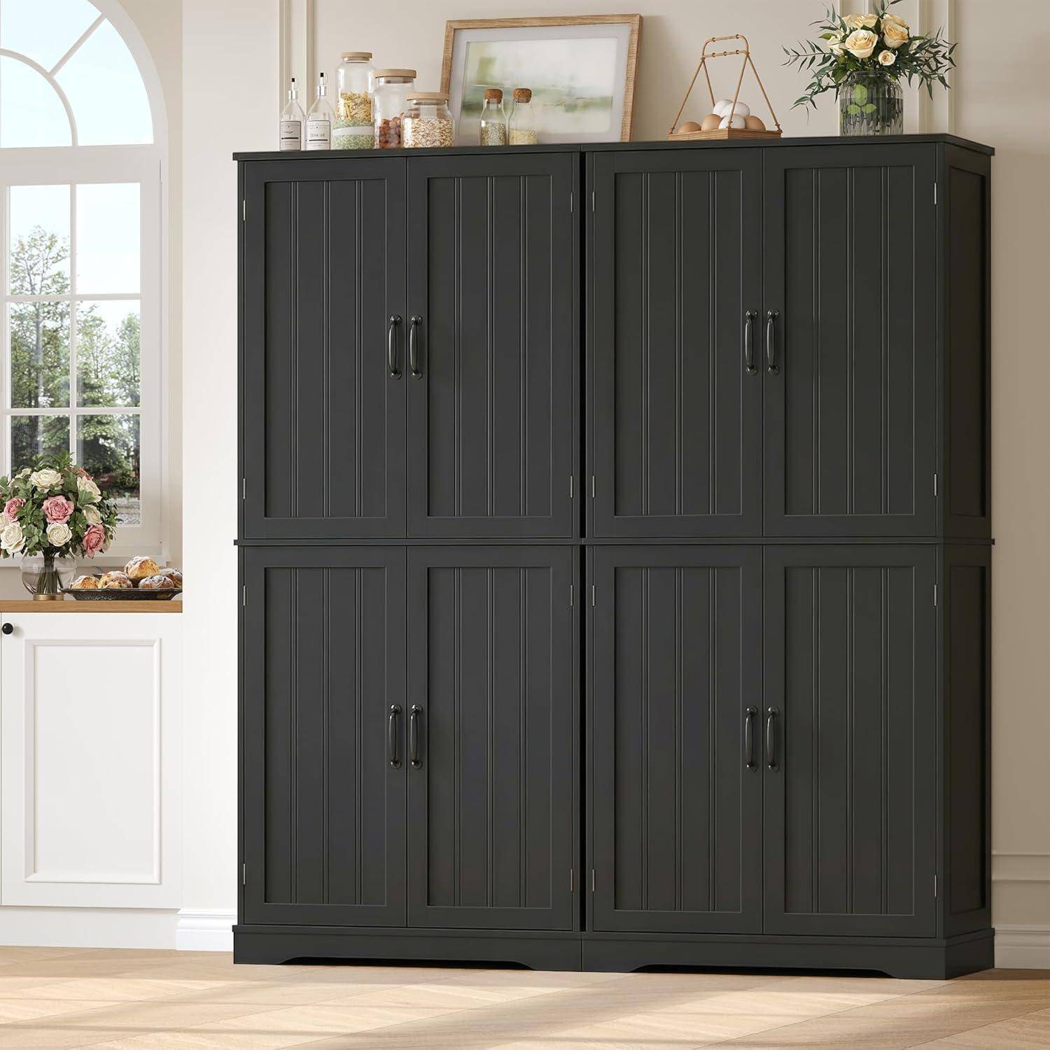 Großer dunkelgrauer viertüriger Schrank mit vertikaler Verkleidung gegen eine helle Wand, oben mit gerahmter Kunst, Gläsern, Blumen und Dekoration.