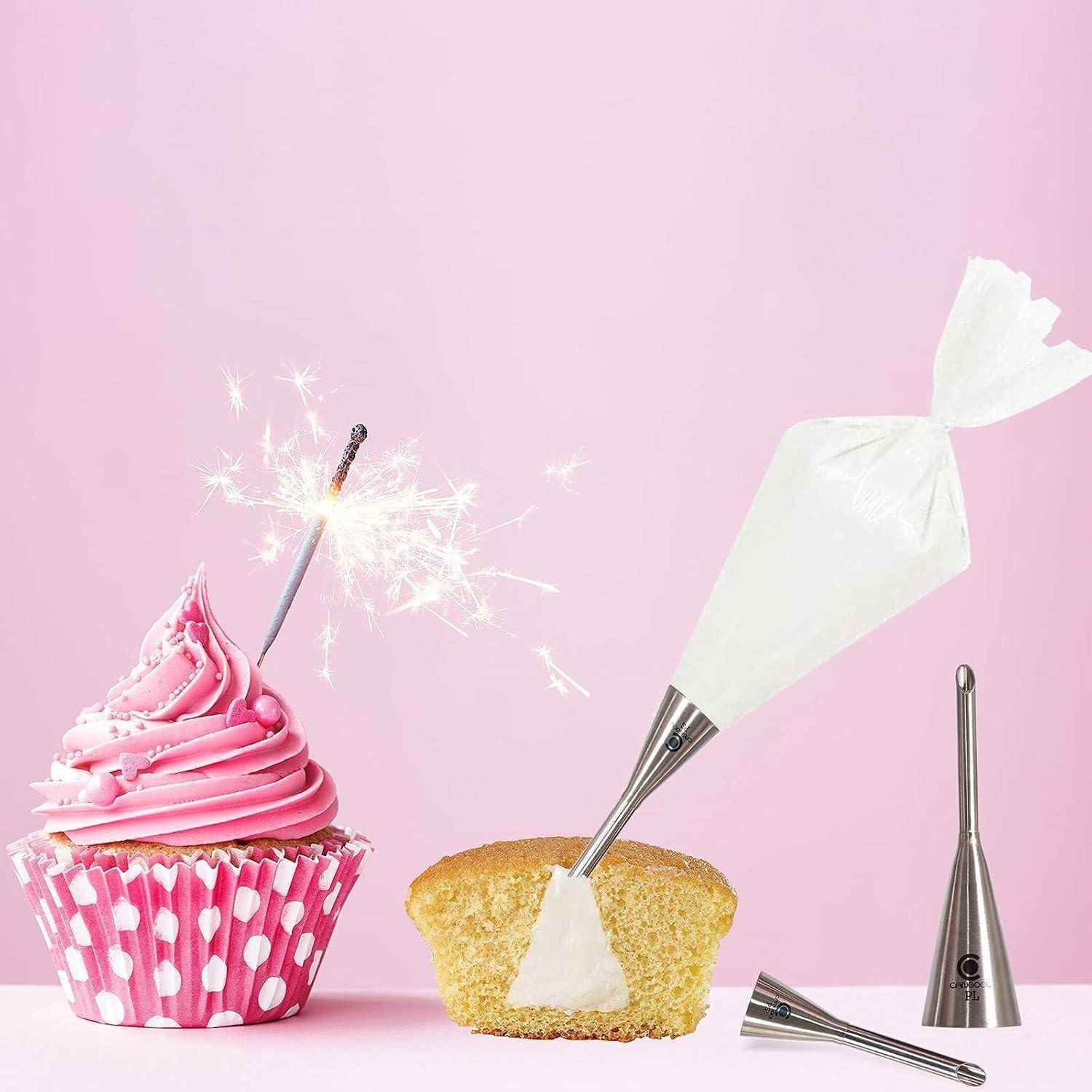 Rosa Cupcake mit einer Wunderkerze und Spritzbeuteln, die ein kleines Kuchenstück auf pastellrosa Hintergrund dekorieren