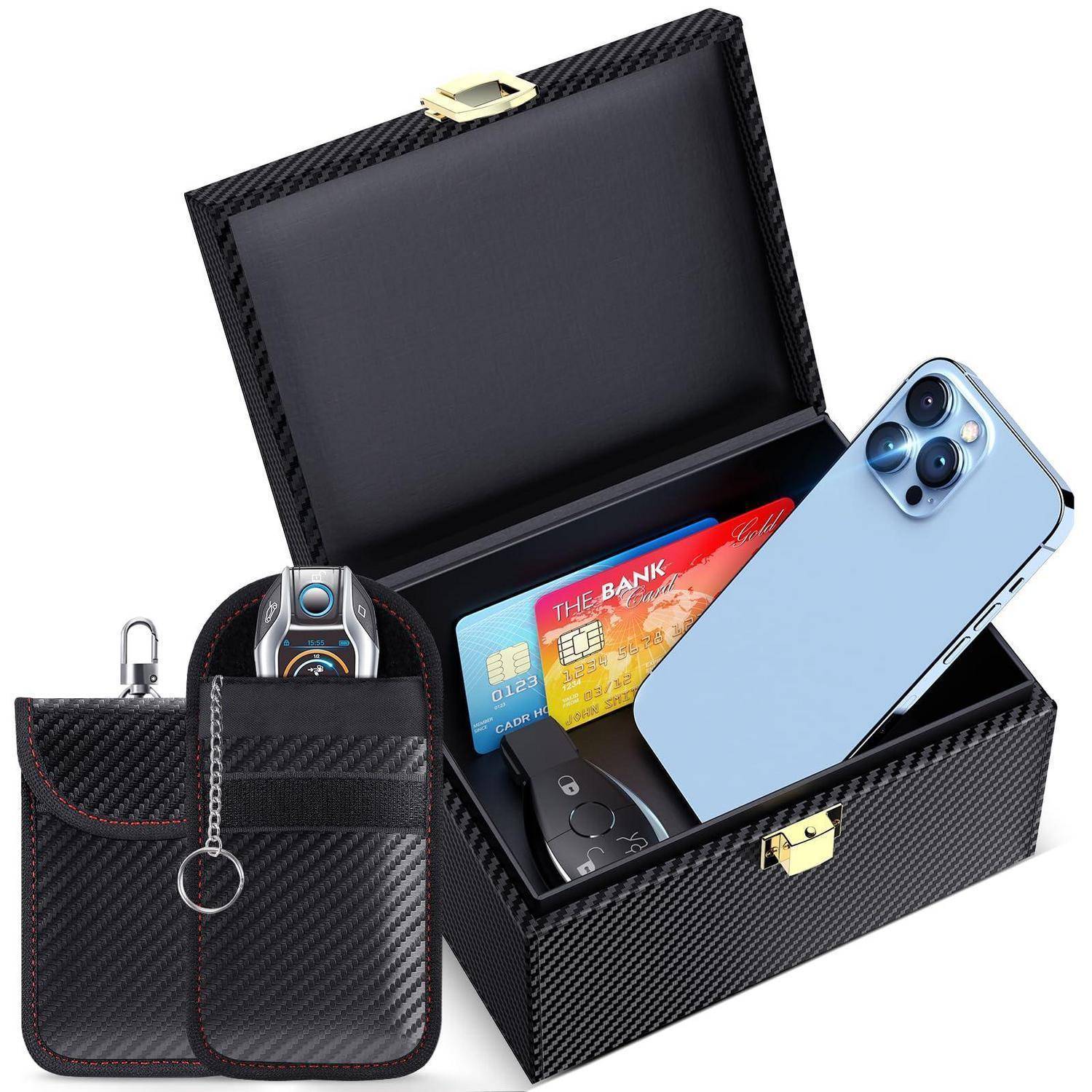 Kohlefaser-Stil Lockbox offen mit einem Smartphone, Kreditkarten, Schlüsseln und einer kleinen Schutzhülle im Inneren; zwei passende Tragetaschen davor.