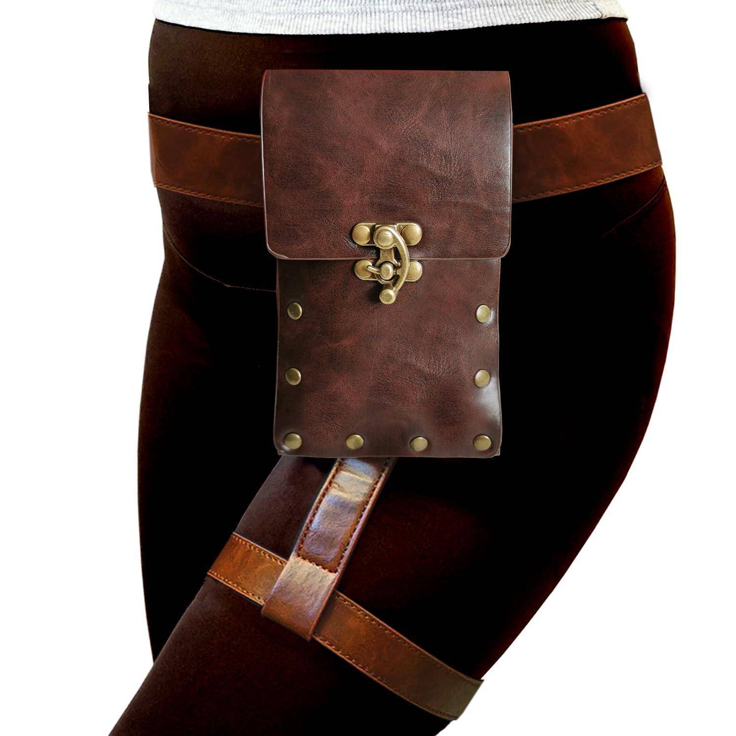 Braune Ledertasche am Oberschenkel, über der dunklen Leggings an einem Bein befestigt, mit Klappenoptik und Messingnieten.