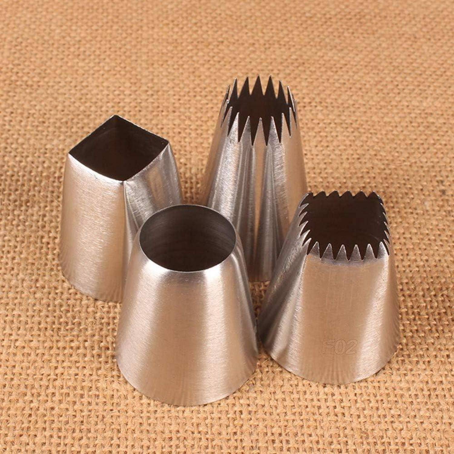 Vier Metallspritzaufsätze zum Verzieren von Gebäck, auf einer Juteoberflä­che dargestellt: quadratische, runde und zwei sternenförmige Spitzen.