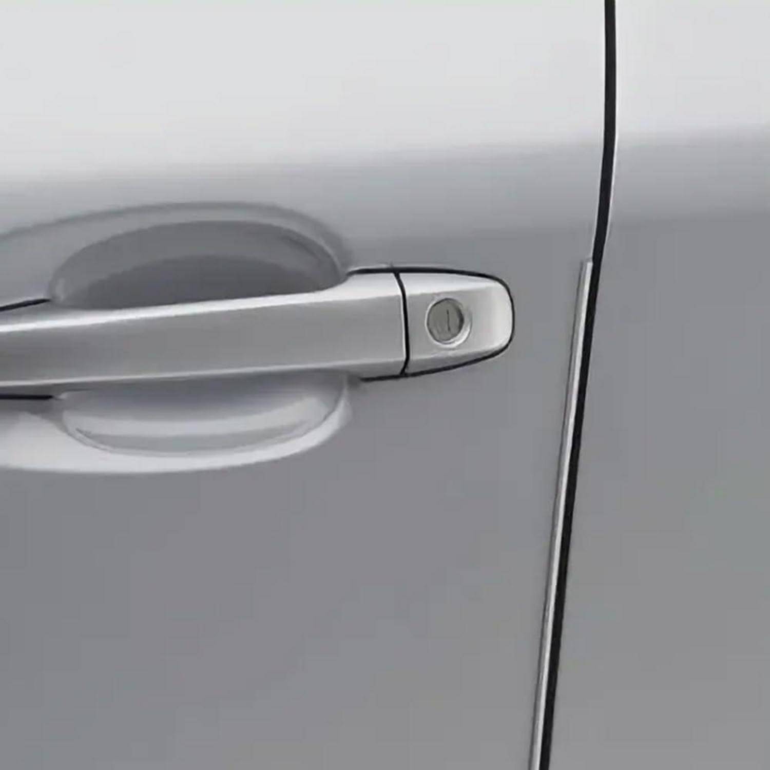 Nahaufnahme eines silbernen Autotürgriffs mit einem Schlüsselloch am rechten Ende.