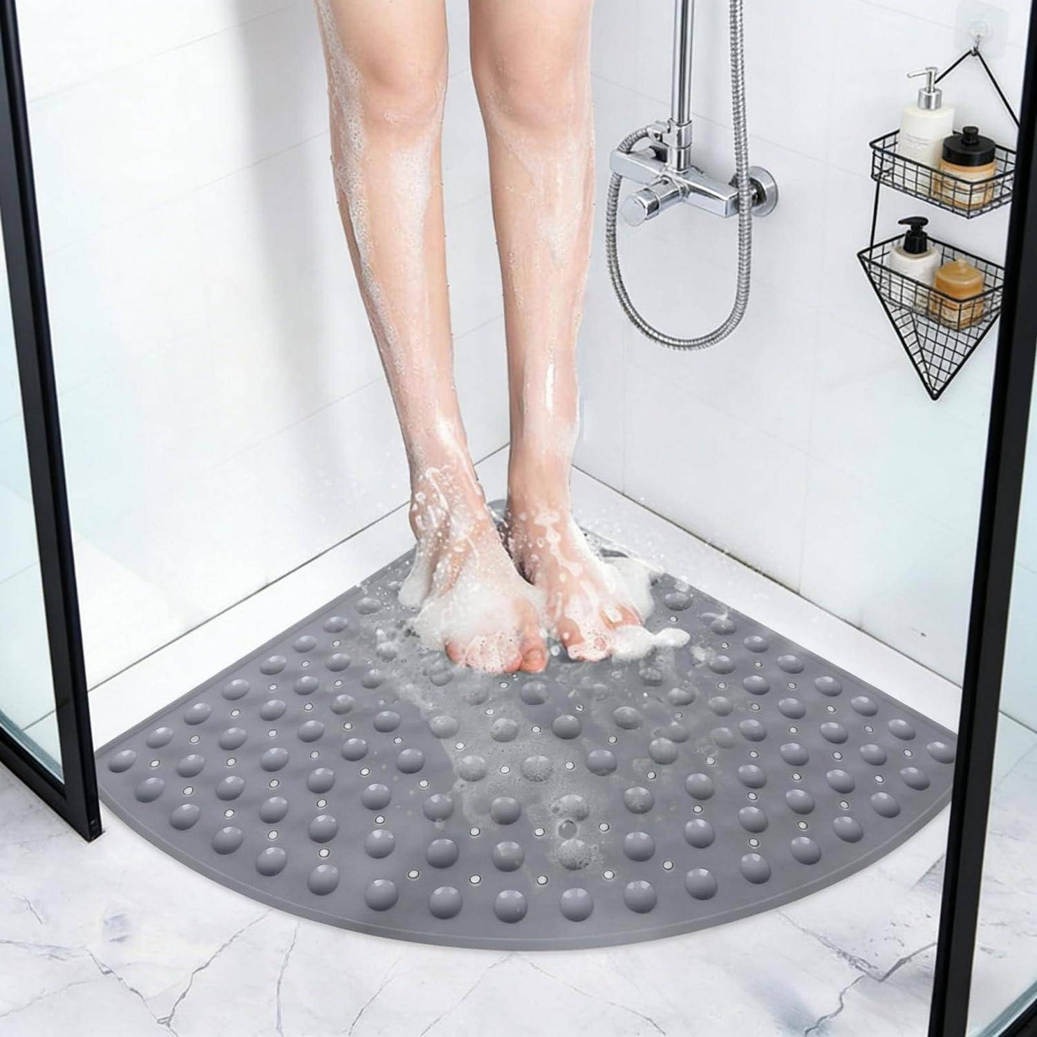 Füße werden in einer Dusche gewaschen, während man auf einer grauen strukturierten Eckbadematte mit Saugnapfnoppen steht.