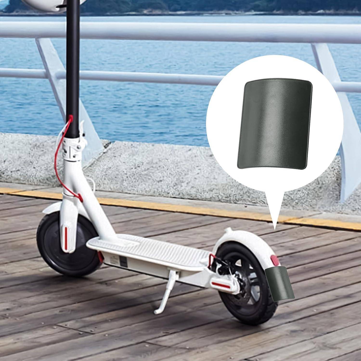 Elektro-Roller auf einer Strandpromenade mit einer Legende, die ein gekrümmtes schwarzes Zubehörteil zeigt, das in der Nähe des Hinterrads angebracht ist.