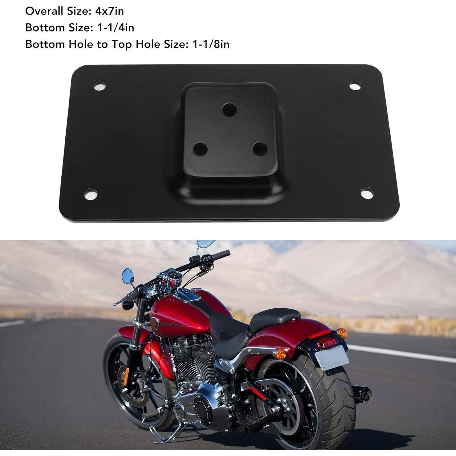 Schwarze Metallmontageplatte mit vier Ecklöchern und erhöhter Mittelfläche, dargestellt über einem roten Cruiser-Motorrad auf einer Straße.