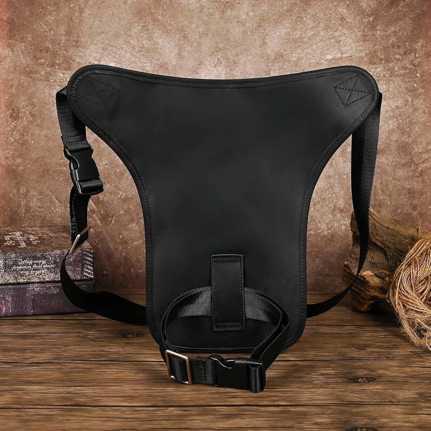 Schwarze taktische Beinholster oder Utility-Tasche mit verstellbaren Riemen, gezeigt auf einer Holzoberfläche vor rustikalem braunem Hintergrund.