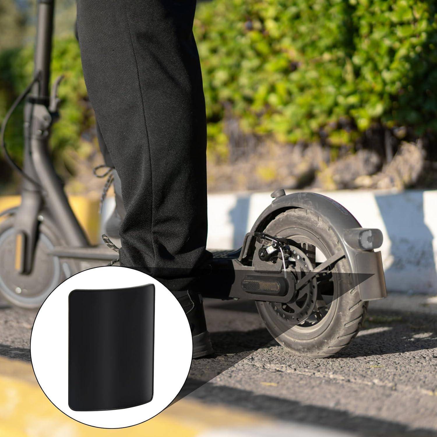 Nahaufnahme des Hinterrads und der Ladefläche eines Elektroscooters mit einem Fahrer, der darauf steht; eine Einblendung zeigt ein schwarzes rechteckiges Batteriepaket.