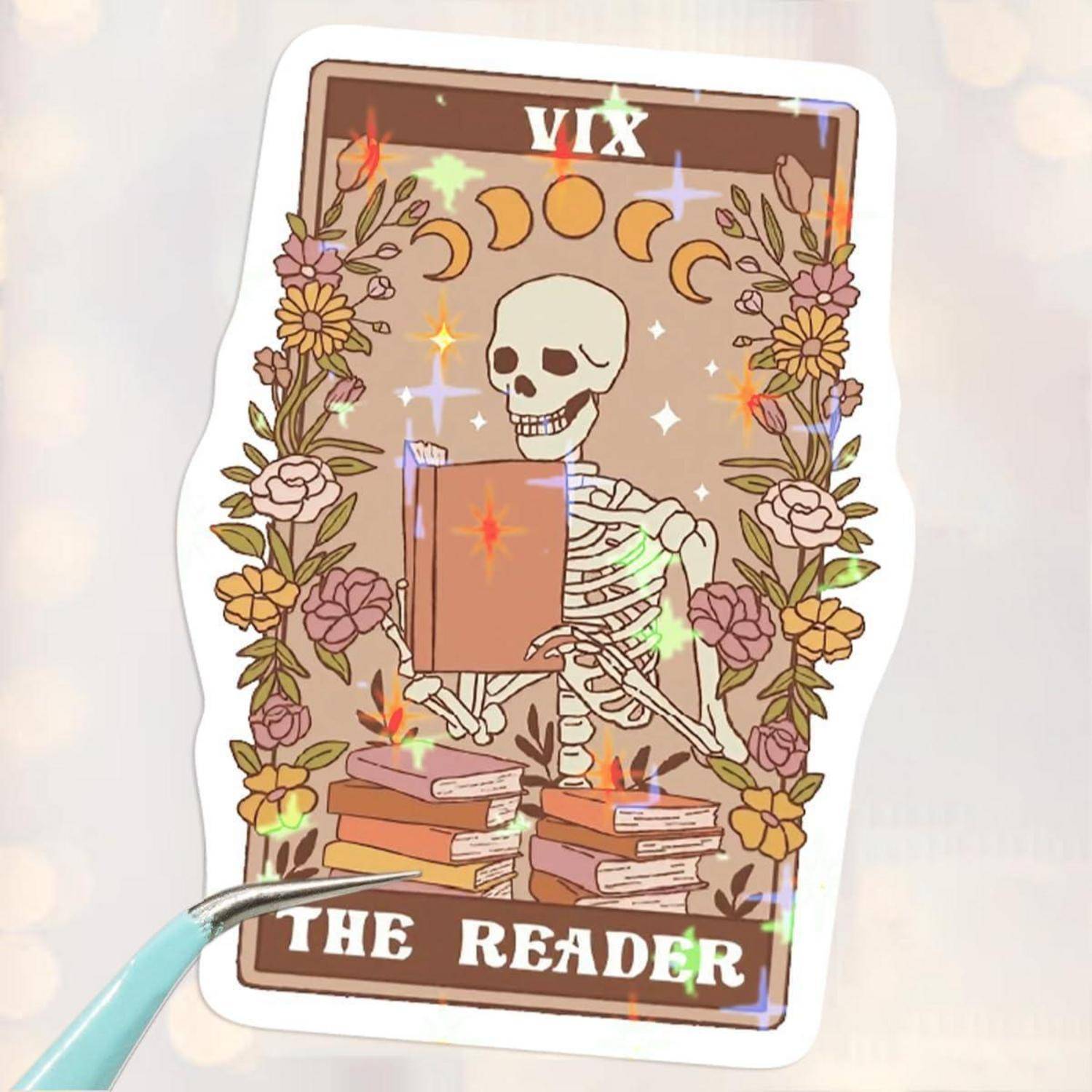 Aufkleber eines Skeletts, das ein Buch liest, umrahmt von Blumen und Mondphasen, mit dem Text 'VIX' und 'THE READER'.