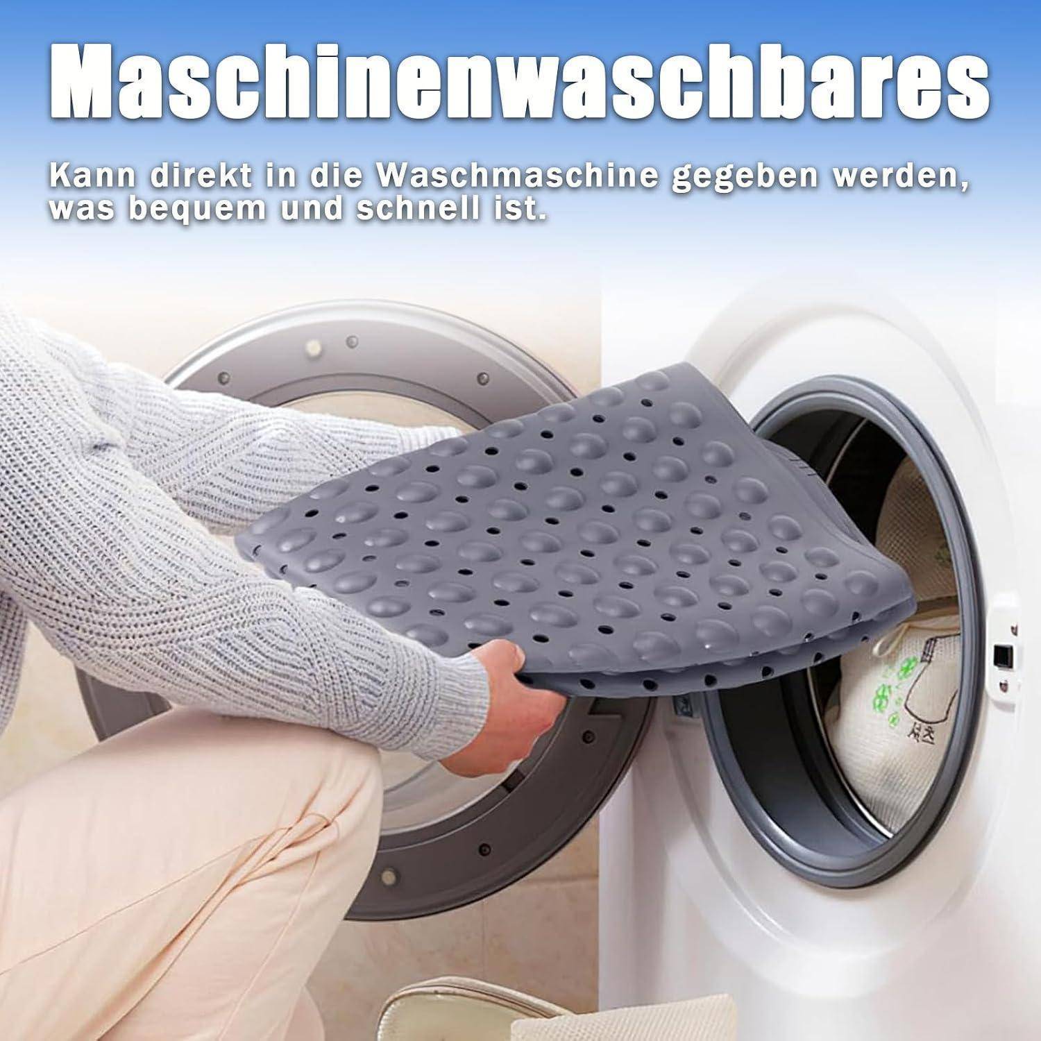 Person lädt eine durchlöcherte graue Matte in eine Frontladerwaschmaschine; der deutsche Text besagt, dass sie maschinenwaschbar ist und direkt in die Waschmaschine gegeben werden kann.