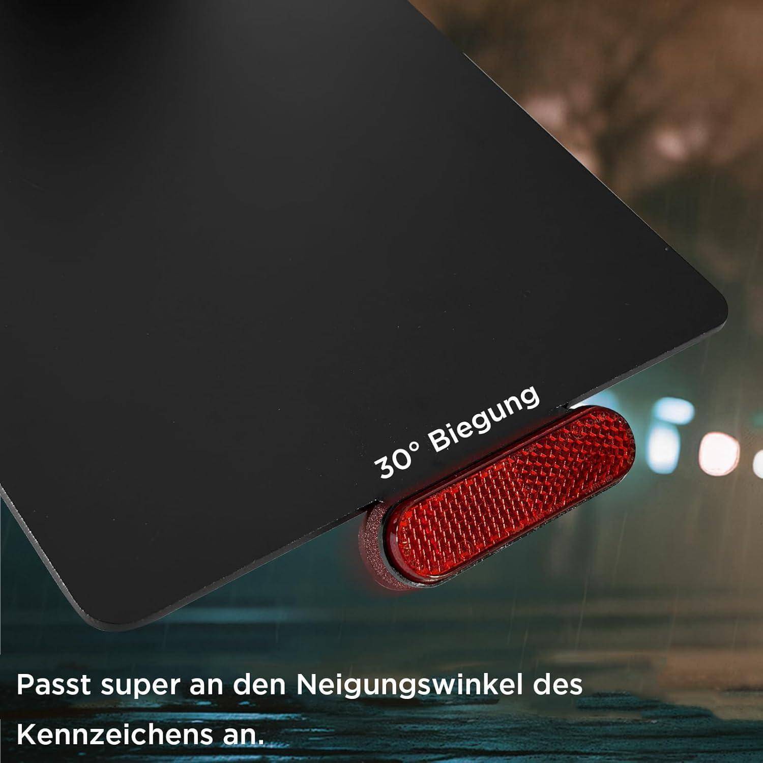 Nahaufnahme eines gekippten Autokennzeichens mit einem roten Reflektor mit der Bezeichnung „30° Biegung