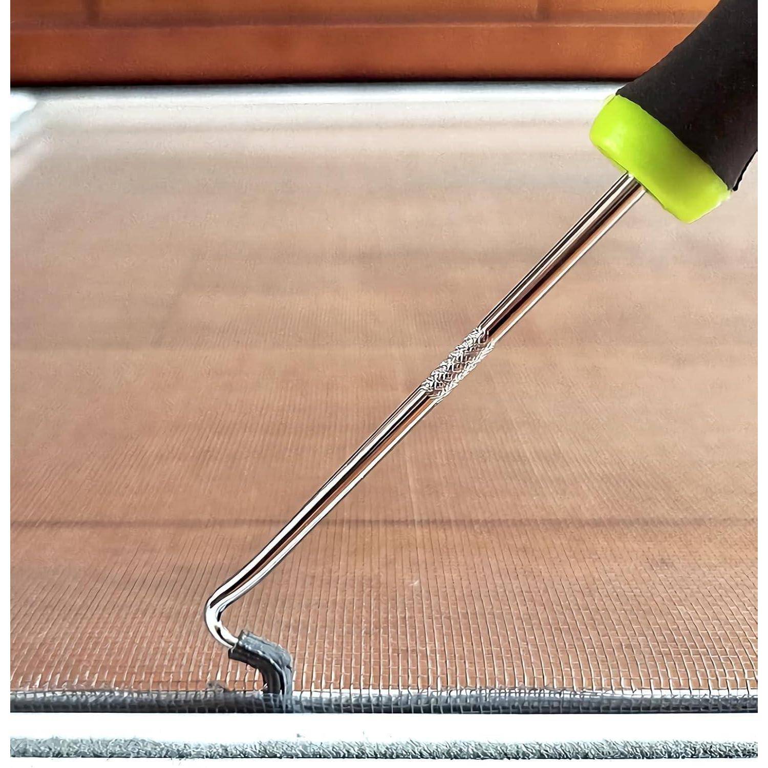 Nahaufnahme eines Werkzeughakens, der eine kleine Stoff- oder Netzkante auf einer Holzoberfläche anhebt, wobei präzise Reparatur- oder Webarbeiten gezeigt werden.