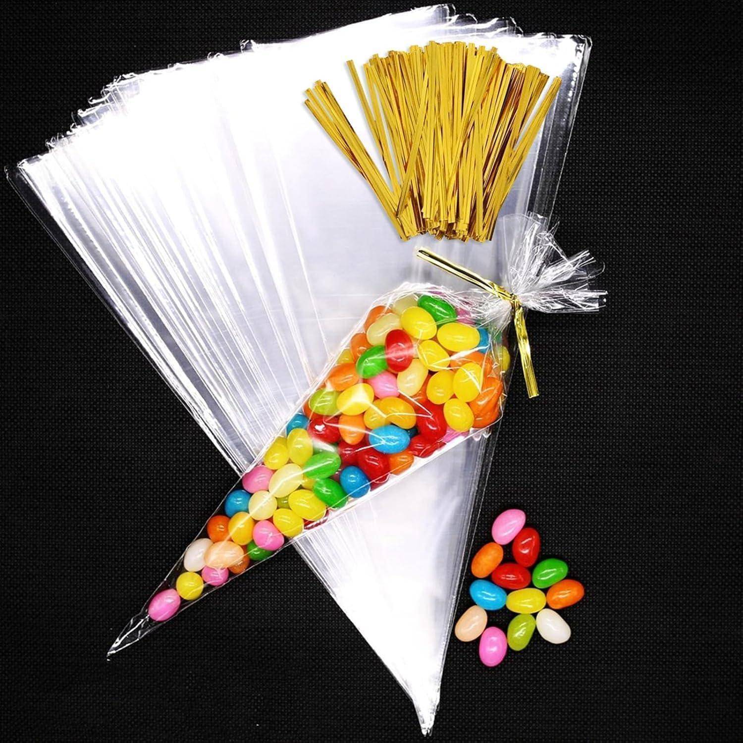 Kunststoff-Spritzbeutel und gelbe Strohhalme neben einer durchsichtigen Kegelförmigen Tüte gefüllt mit bunten Geleebohnen, plus eine kleine Verschüttung von Bohnen auf dunklem Hintergrund.