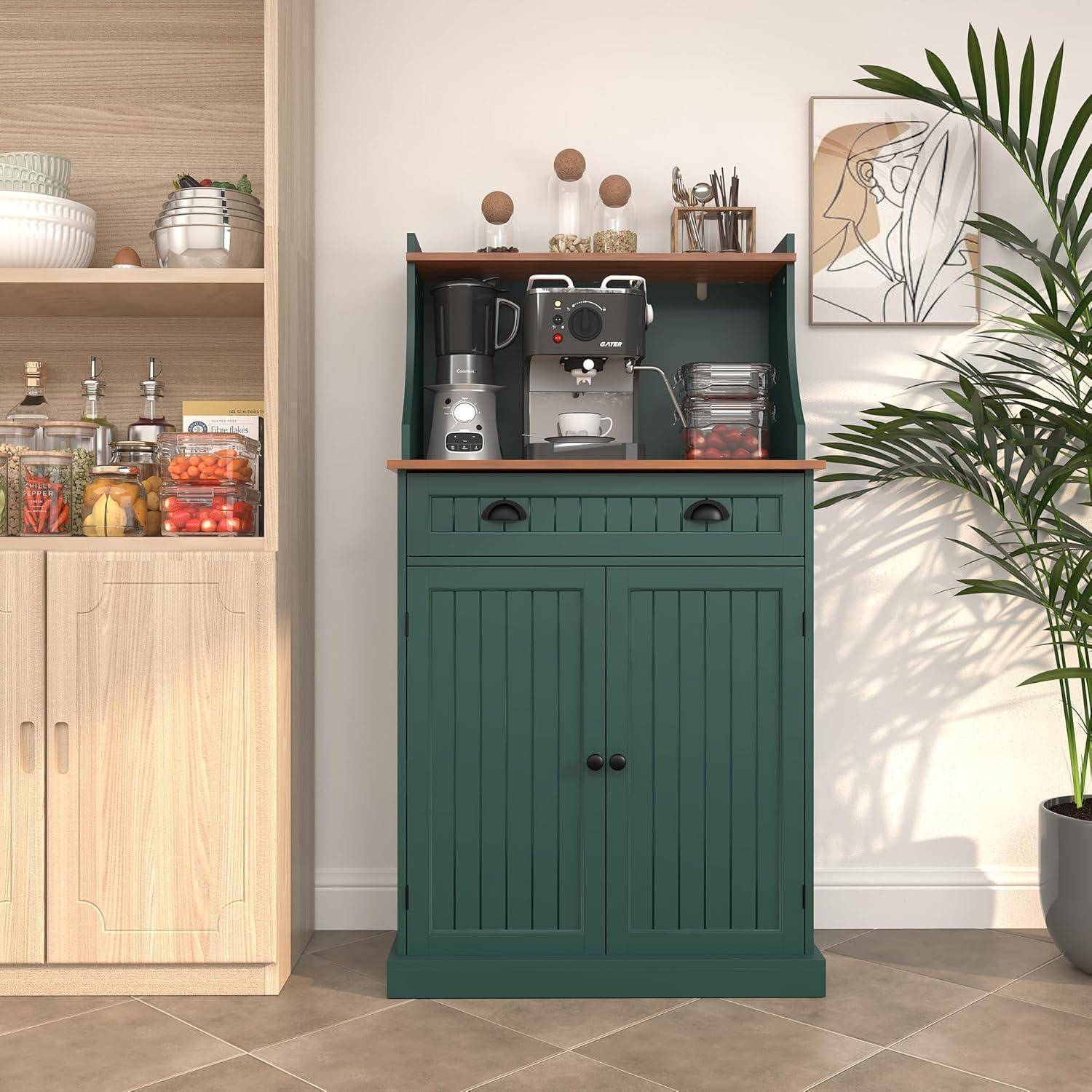 Grüner Küchenschrank mit Kaffeemaschine, Tassen und Gläsern, neben einem hellem Holz-Speisekammerschrank und einer hohen Topfpflanze.