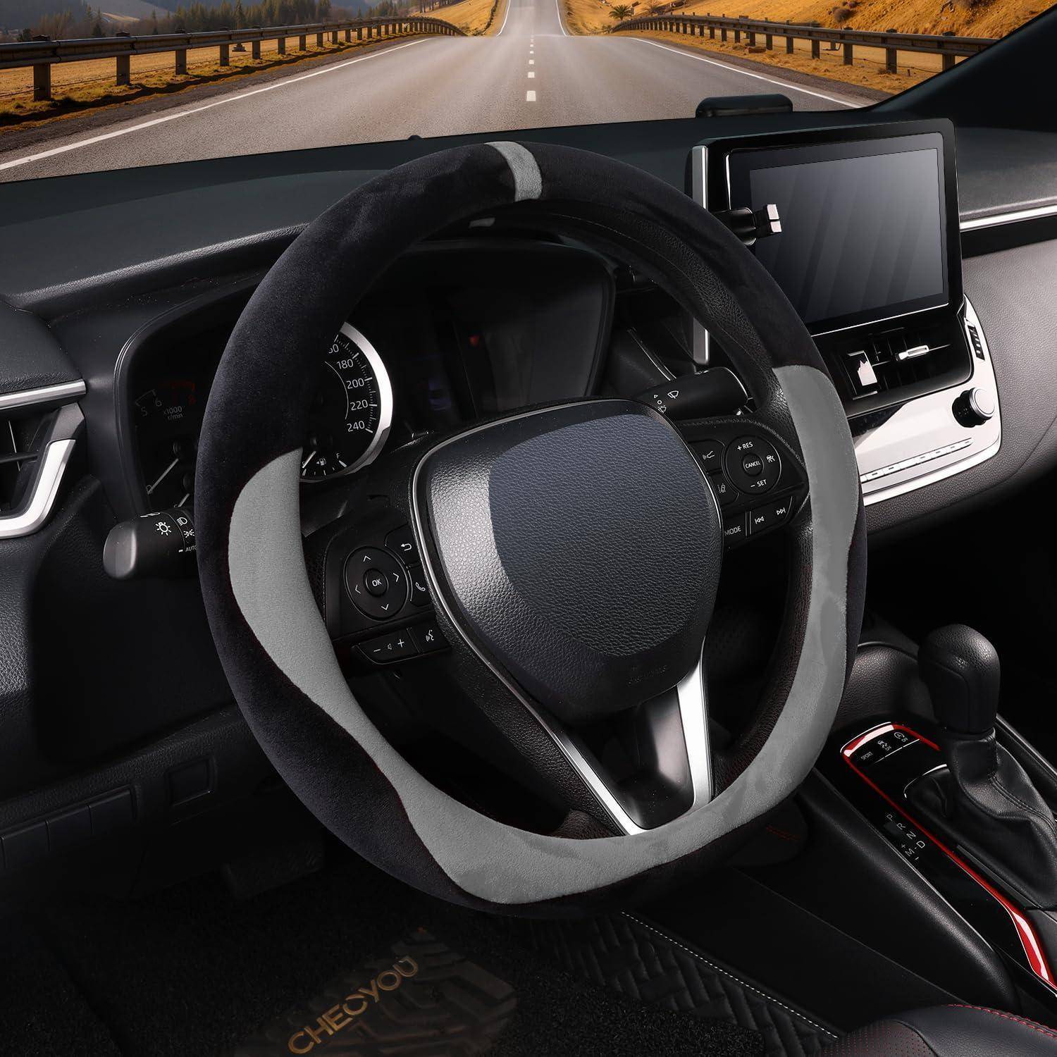 Innenraum eines modernen Autos, das Lenkrad, das Armaturenbrett und das zentrale Display mit einer offenen Straße sichtbar zeigen, die durch die Windschutzscheibe nach vorne führt.