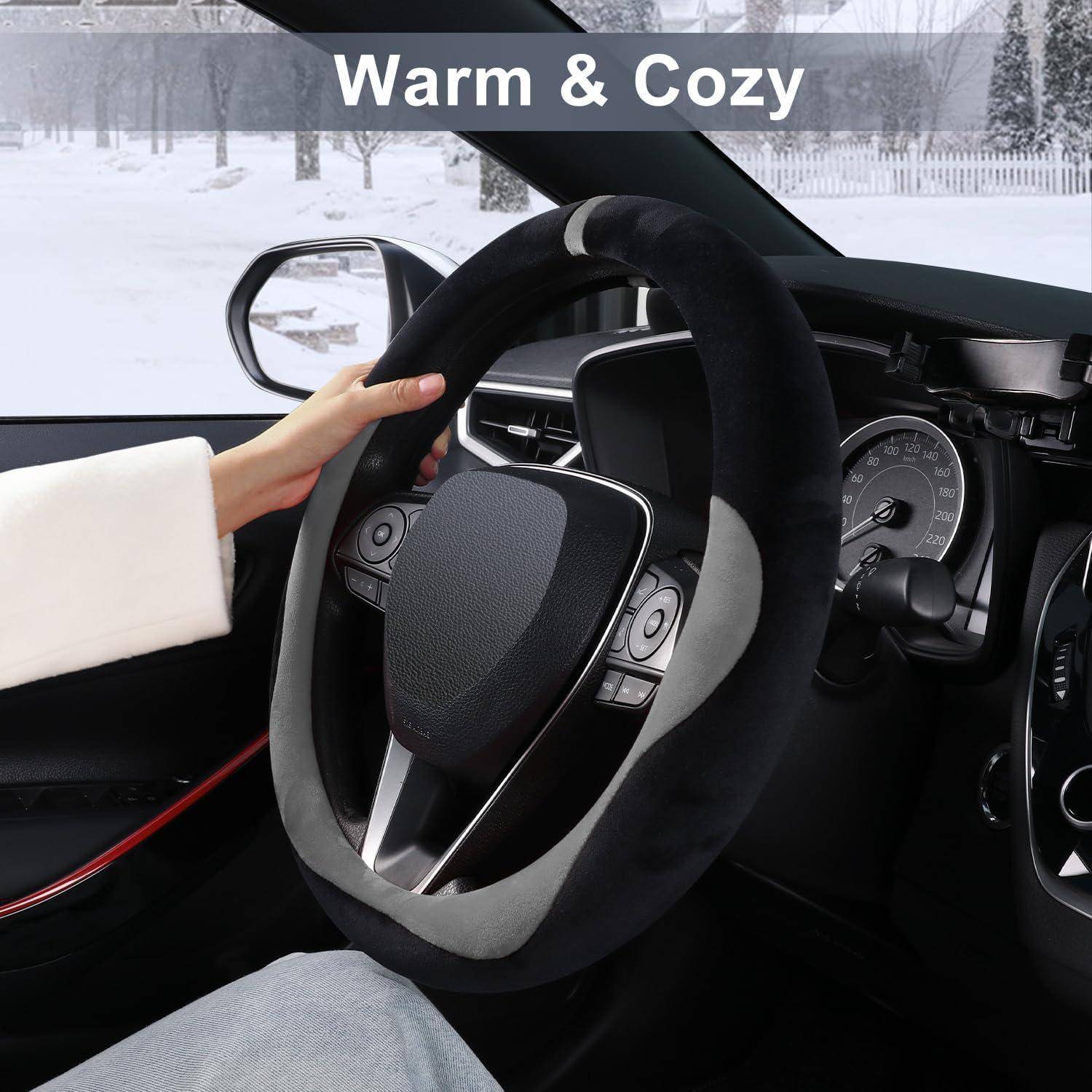 Person, die an einem Winterabend ein Auto mit einem kuscheligen Lenkradbezug mit der Aufschrift "Warm & Cozy"" fährt.