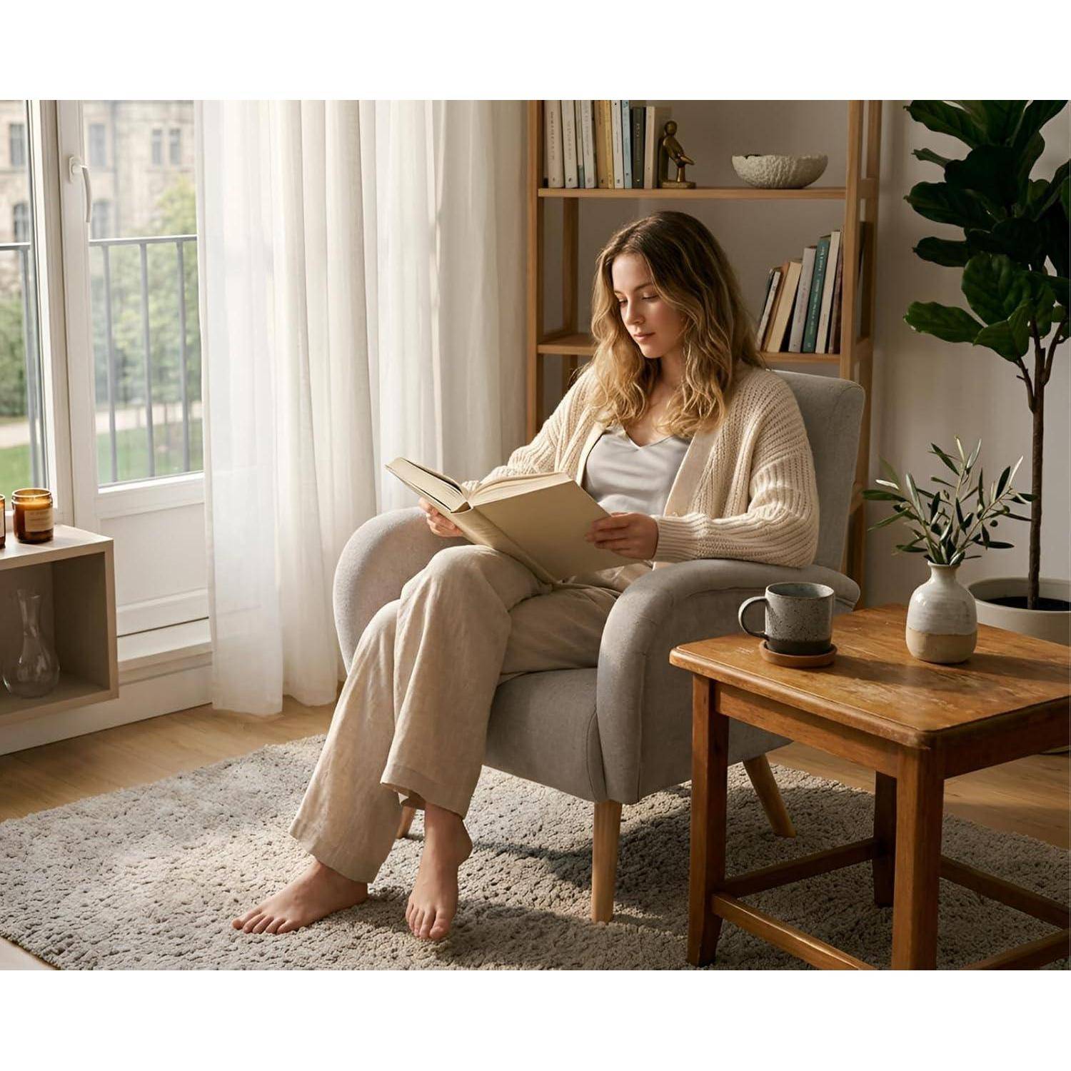 Frau, die ein Buch in einem gemütlichen Wohnzimmer liest, sitzt in einem Sessel neben einem Fenster, mit einem Beistelltisch und einem Bücherregal in der Nähe.