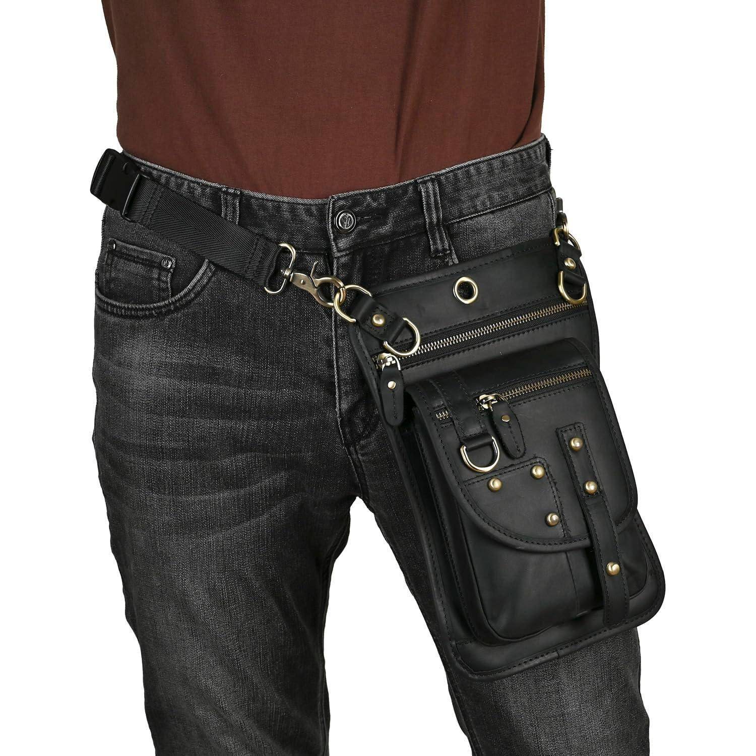 Schwarze taktische Oberschenkeltasche mit Reißverschlüssen und Riemen, die an einer schwarzen Jeanshose an der Hüfte einer Person befestigt ist.