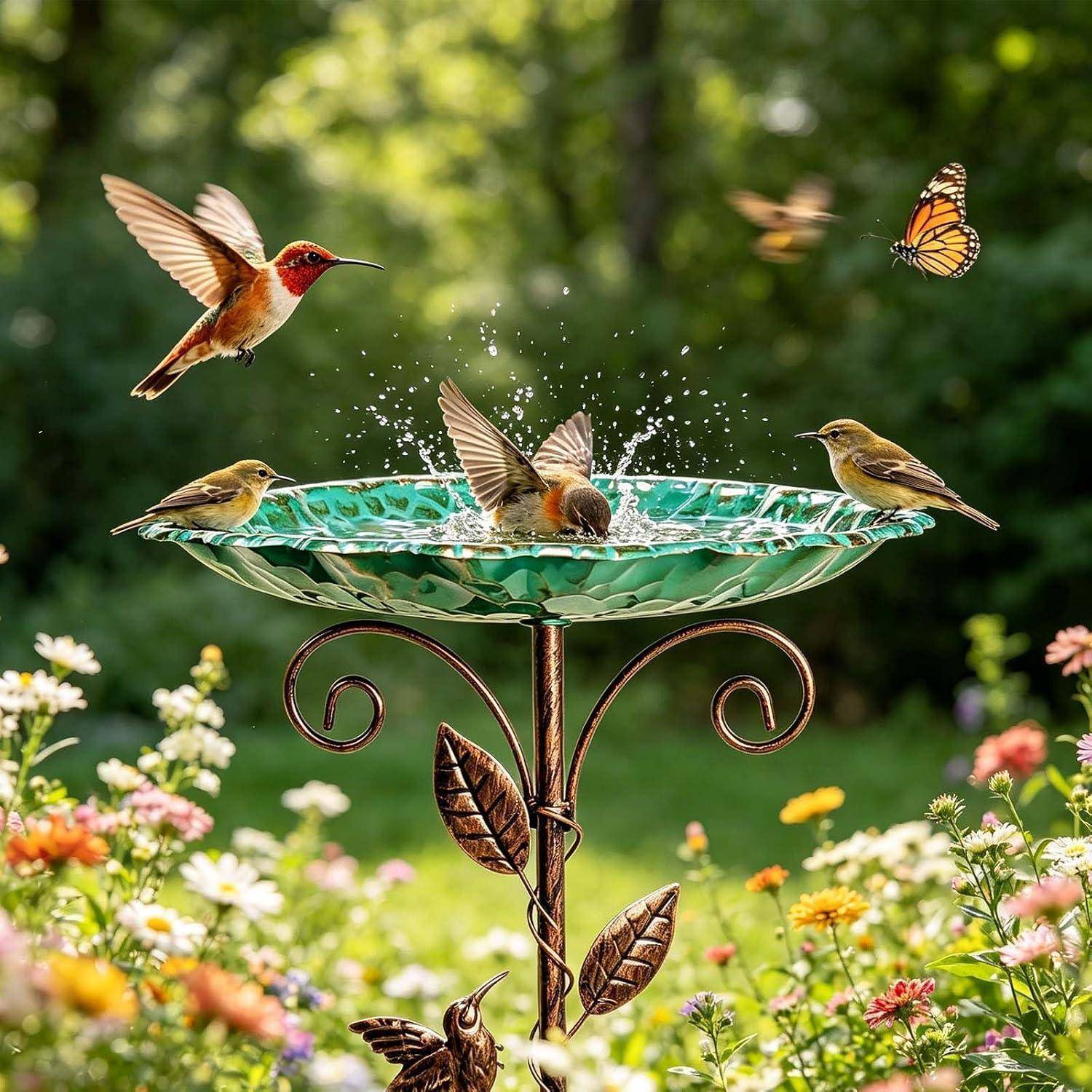 Mehrere Kolibris und kleine Vögel versammeln sich an einem grünen Garten-Vogelbad, wobei ein Kolibri im Flug ist und ein Schmetterling in der Nähe von Blumen schwebt.